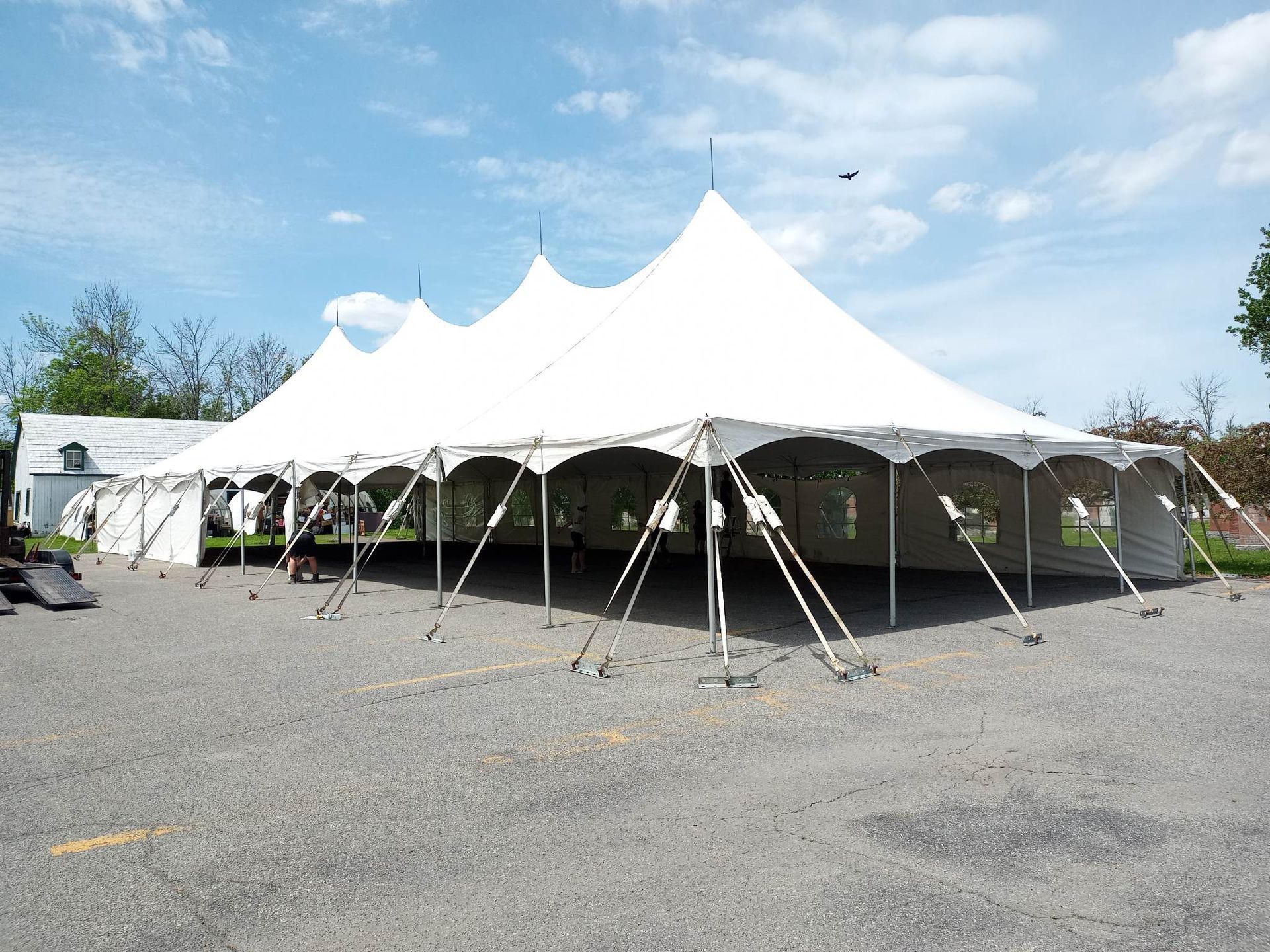 Une grande tente blanche est installée sur un parking