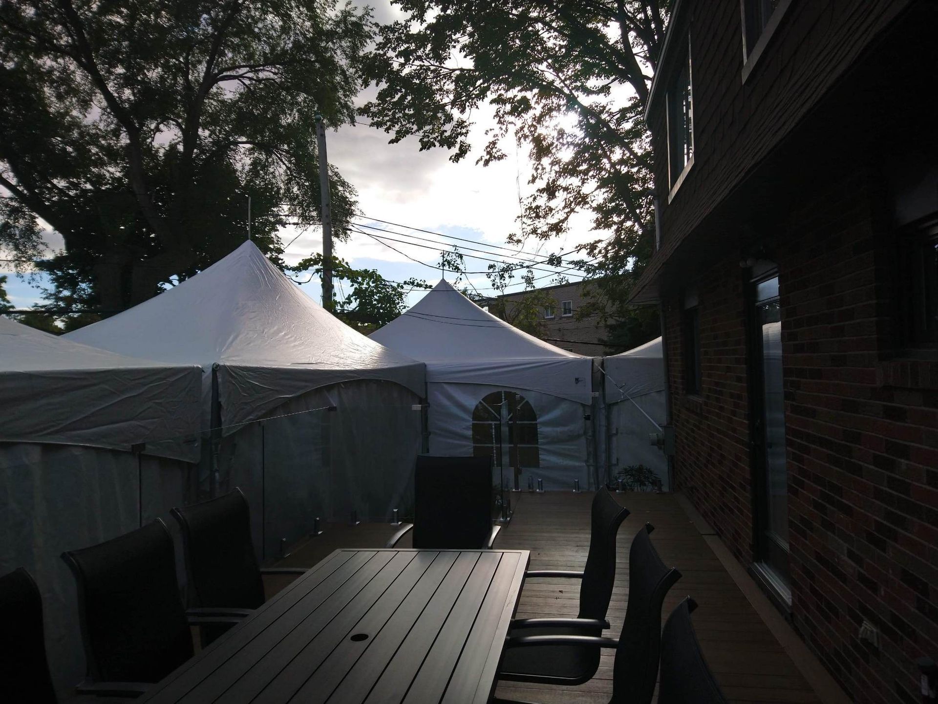 Un patio avec une table et des chaises et des tentes en arrière-plan