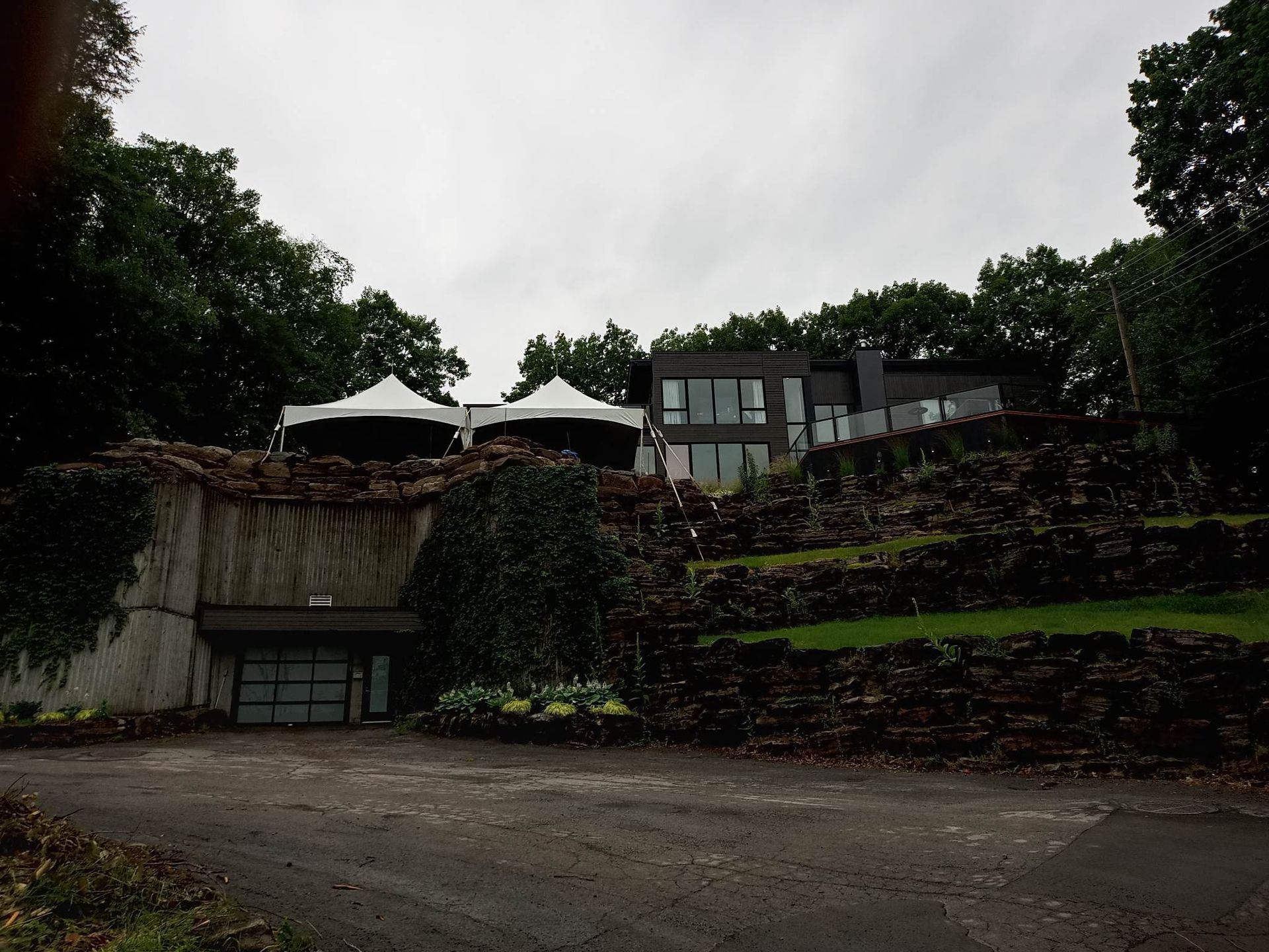 Une grande maison se trouve au sommet d une colline entourée d arbres