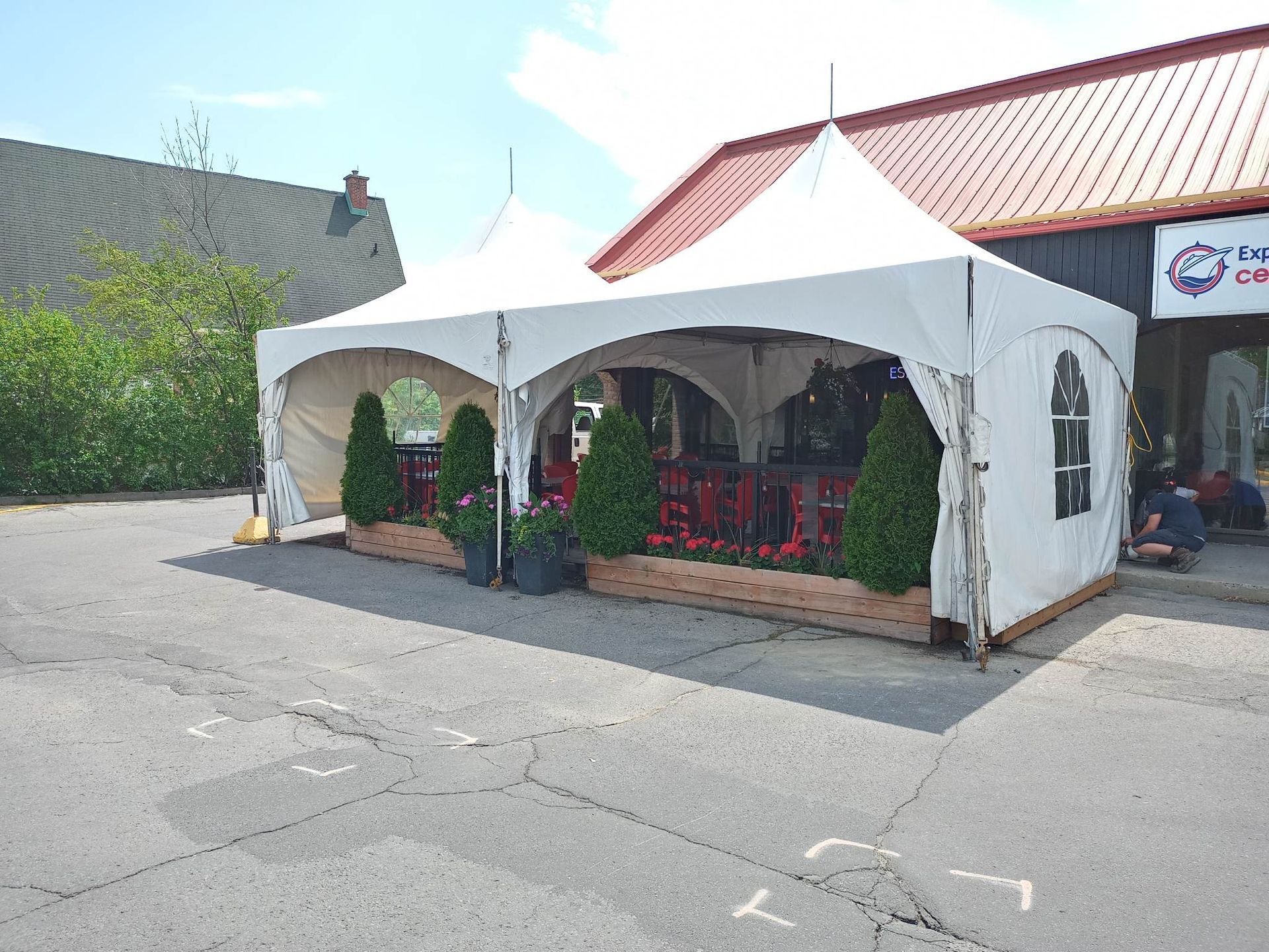 Une tente blanche est installée devant un bâtiment.