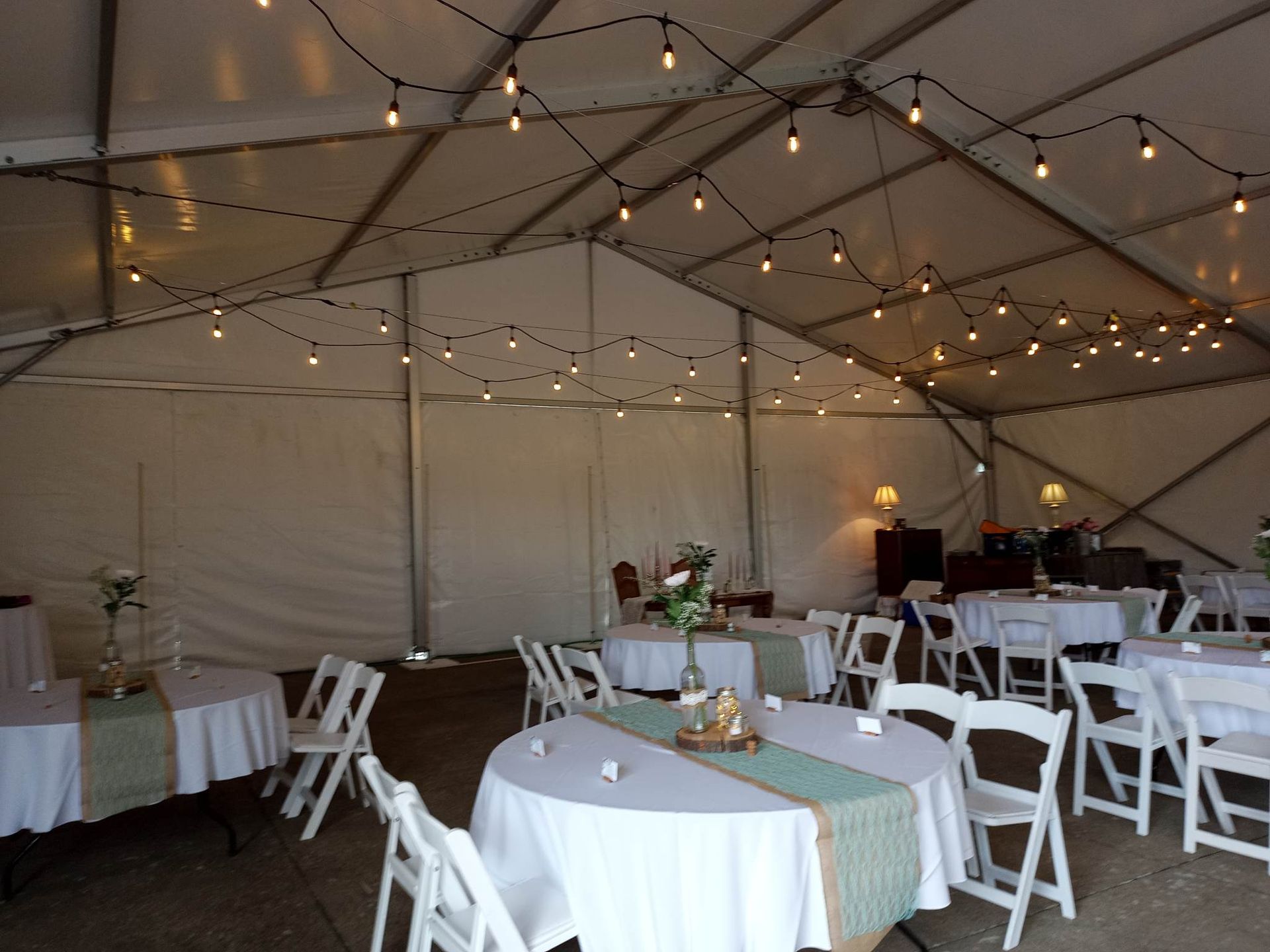 Une tente avec tables et chaises installées pour une réception de mariage