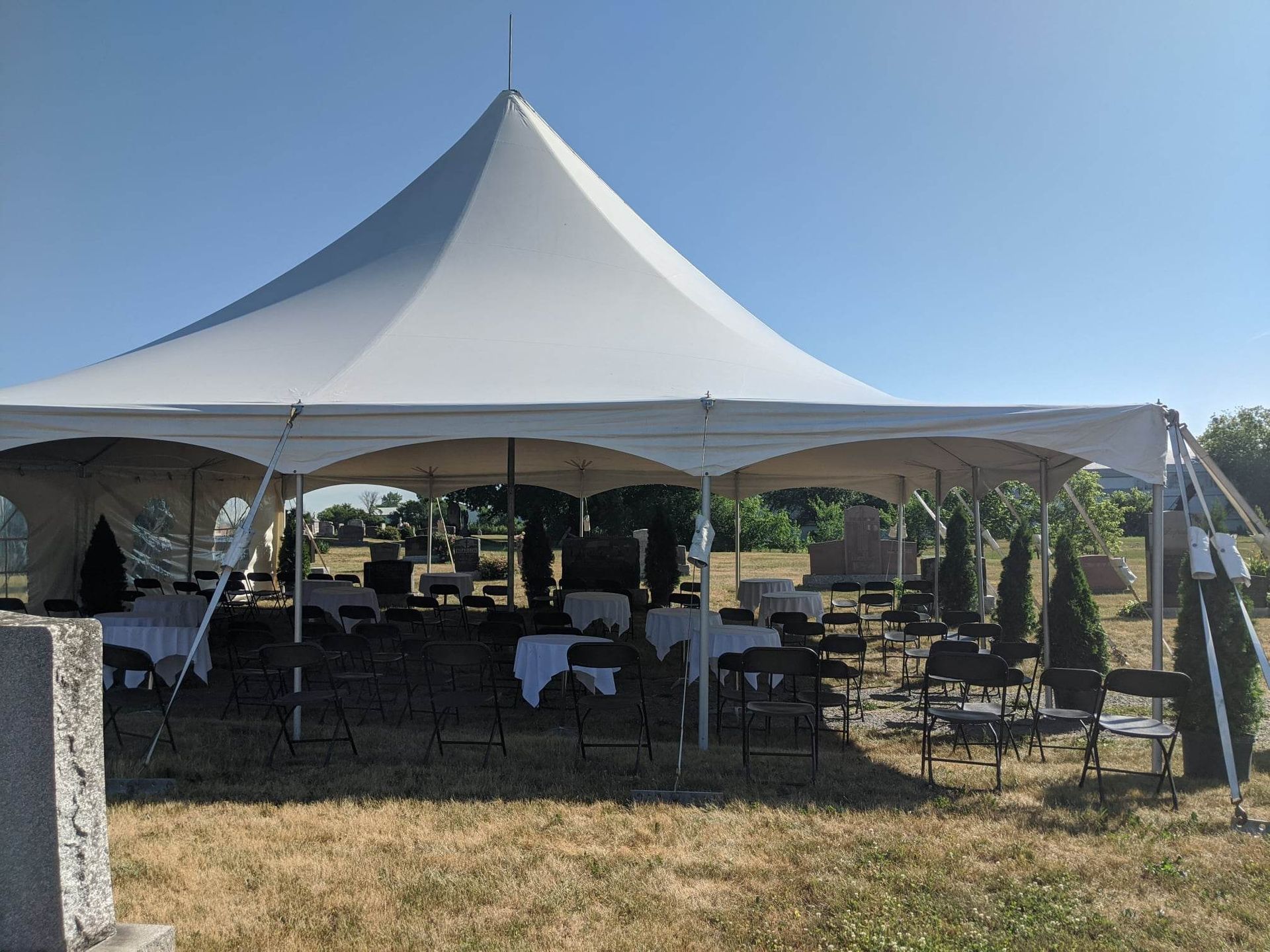 Une grande tente blanche est dressée au milieu d’un champ.