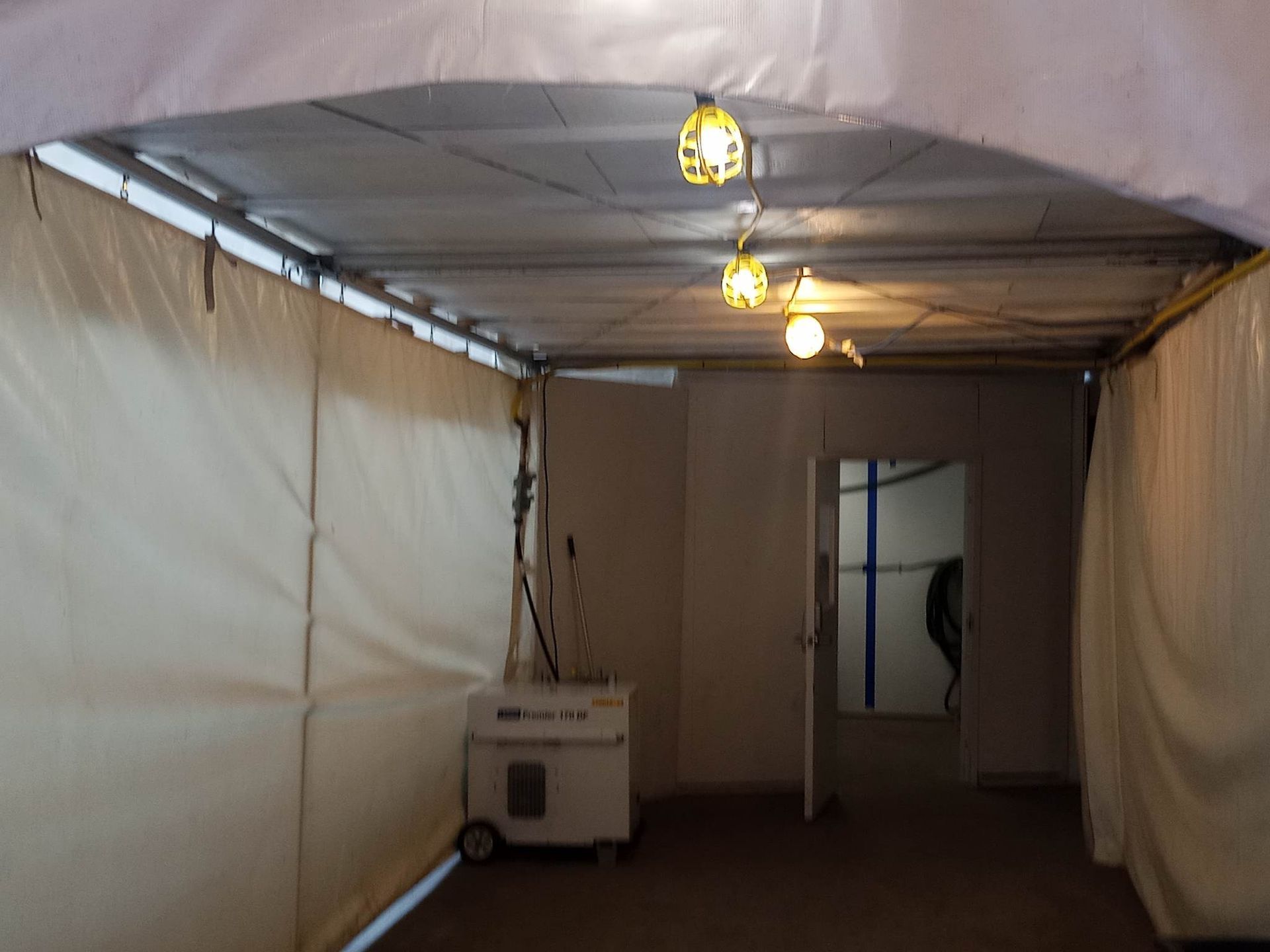 Une pièce vide avec un générateur et des lumières suspendues au plafond