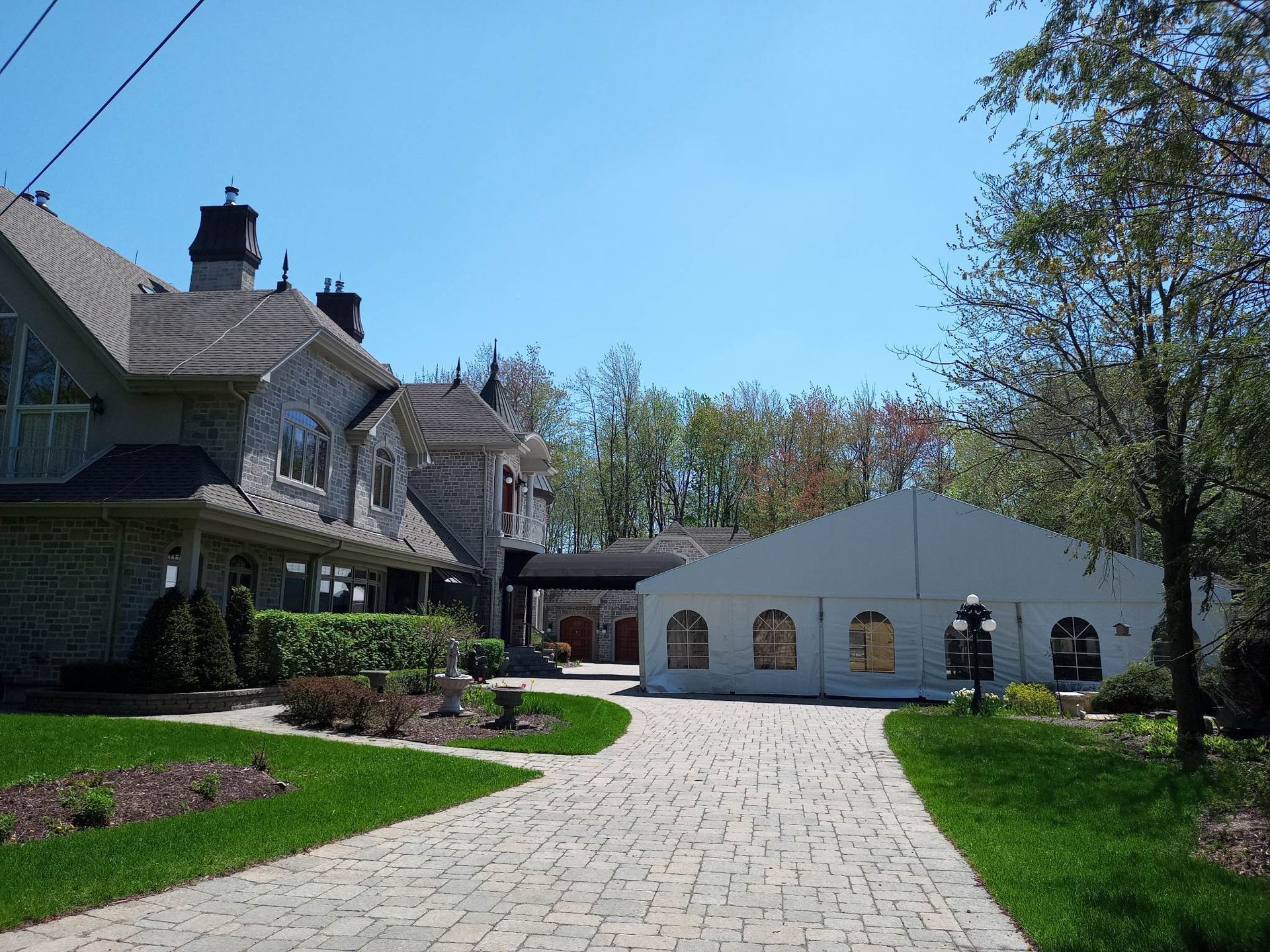 Une grande maison avec une tente blanche devant elle