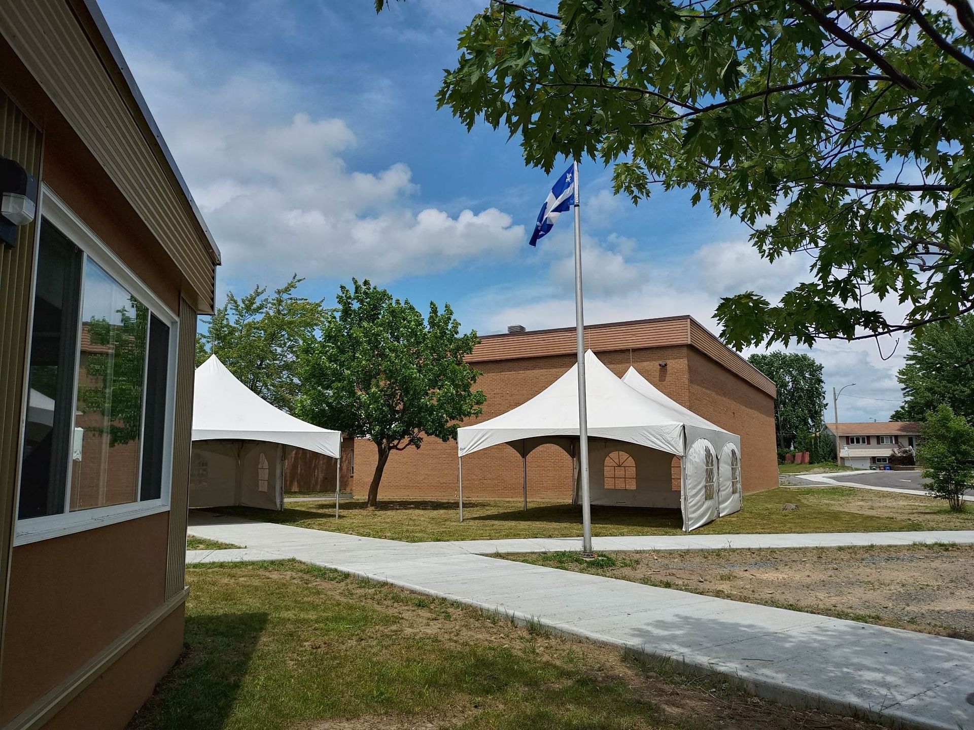 Un drapeau flotte devant un bâtiment avec des tentes devant lui