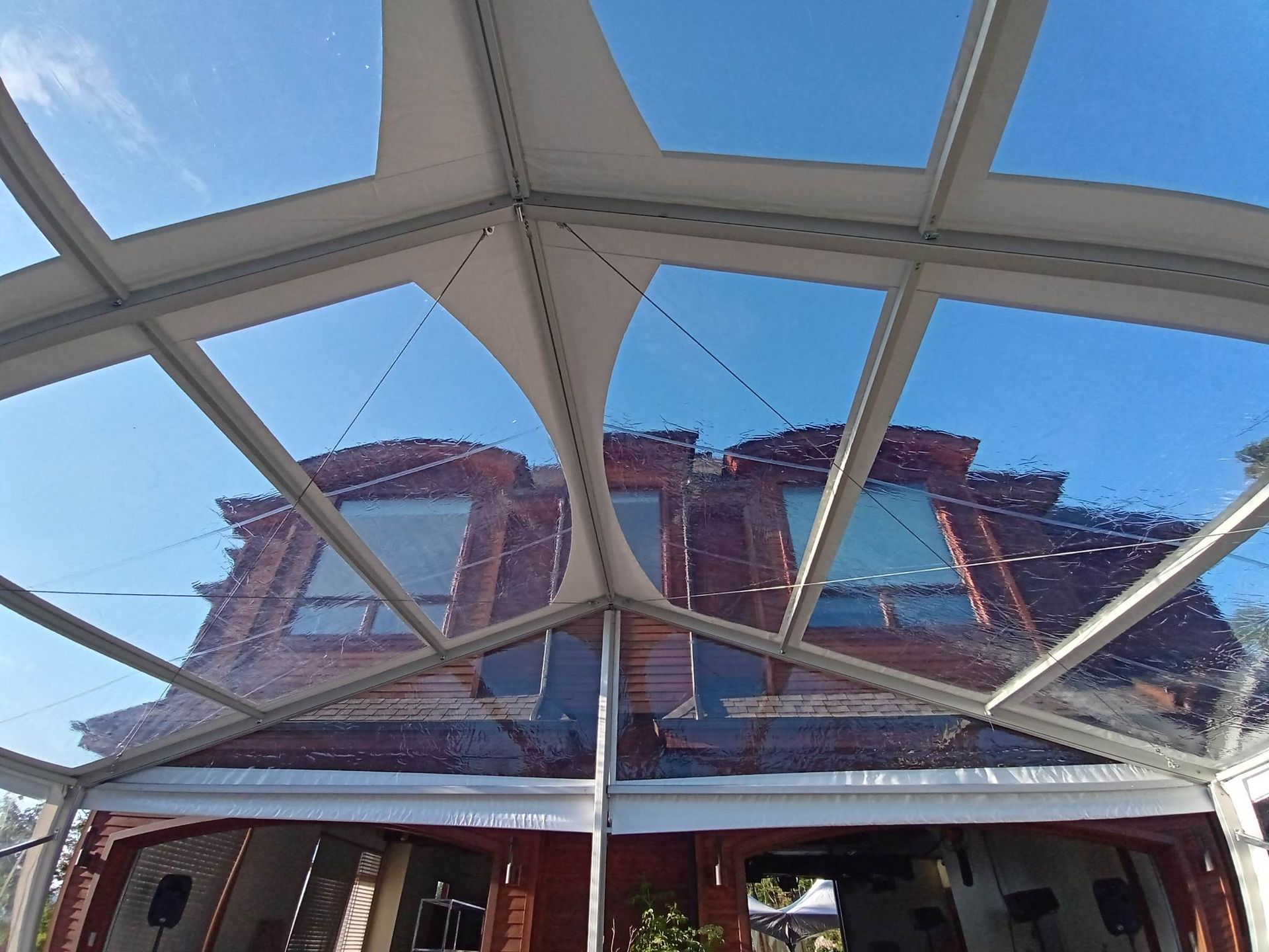 Une tente transparente est installée devant une maison.