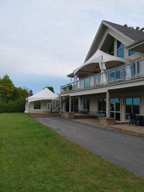Une grande maison blanche avec une grande pelouse devant elle