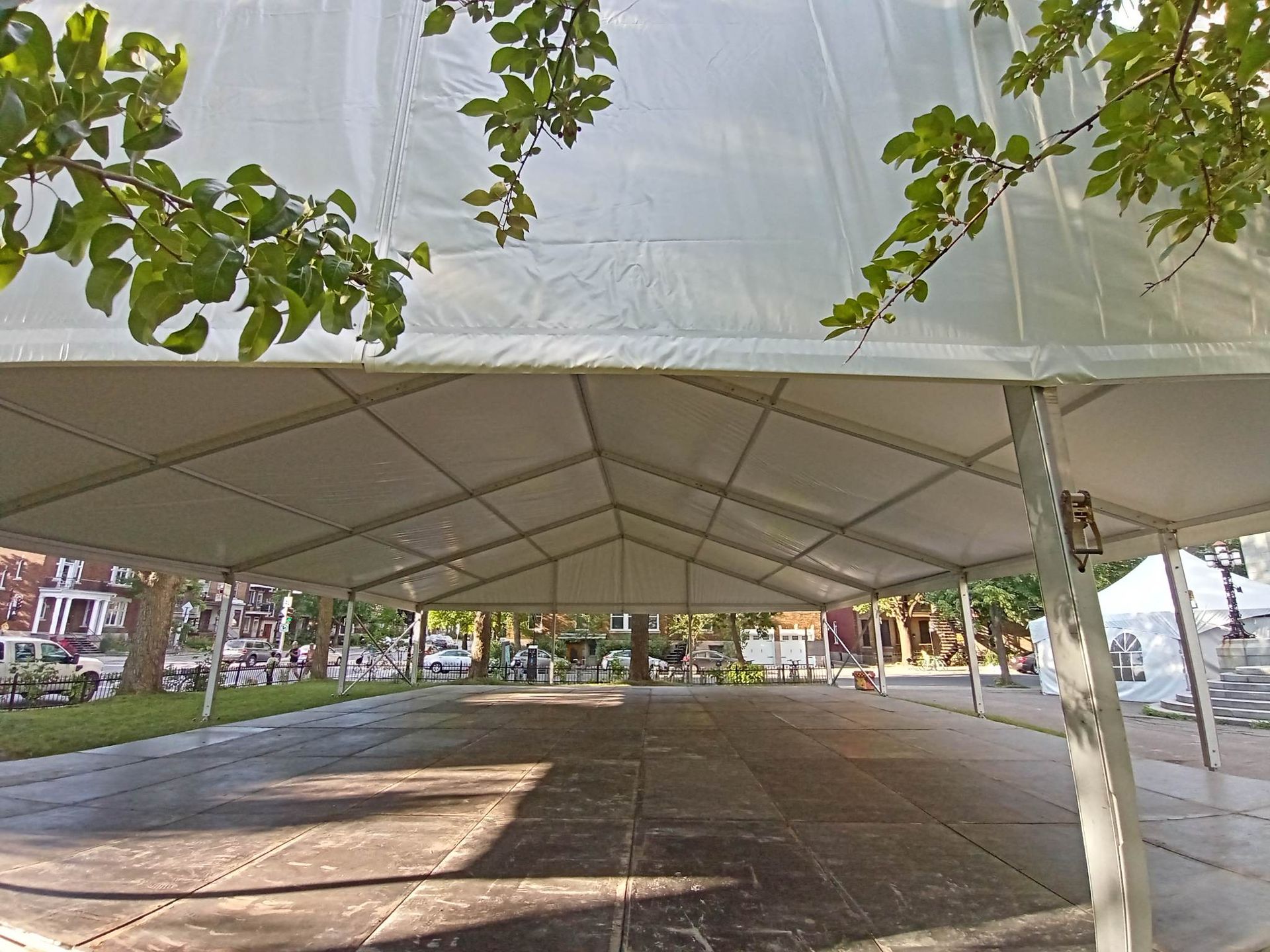 Une grande tente blanche avec un plancher en bois en dessous