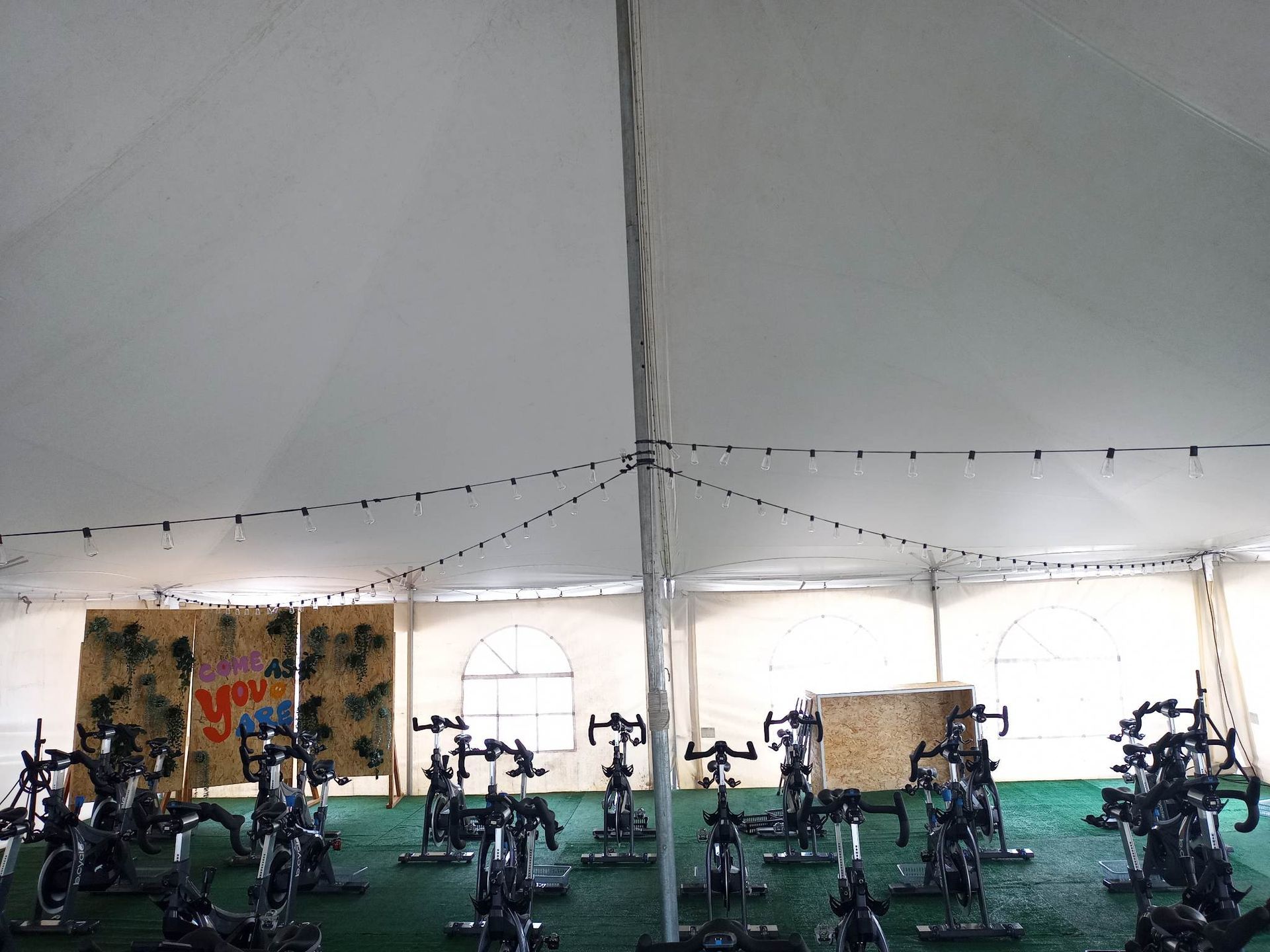 Une rangée de vélos d'exercice sous une tente blanche
