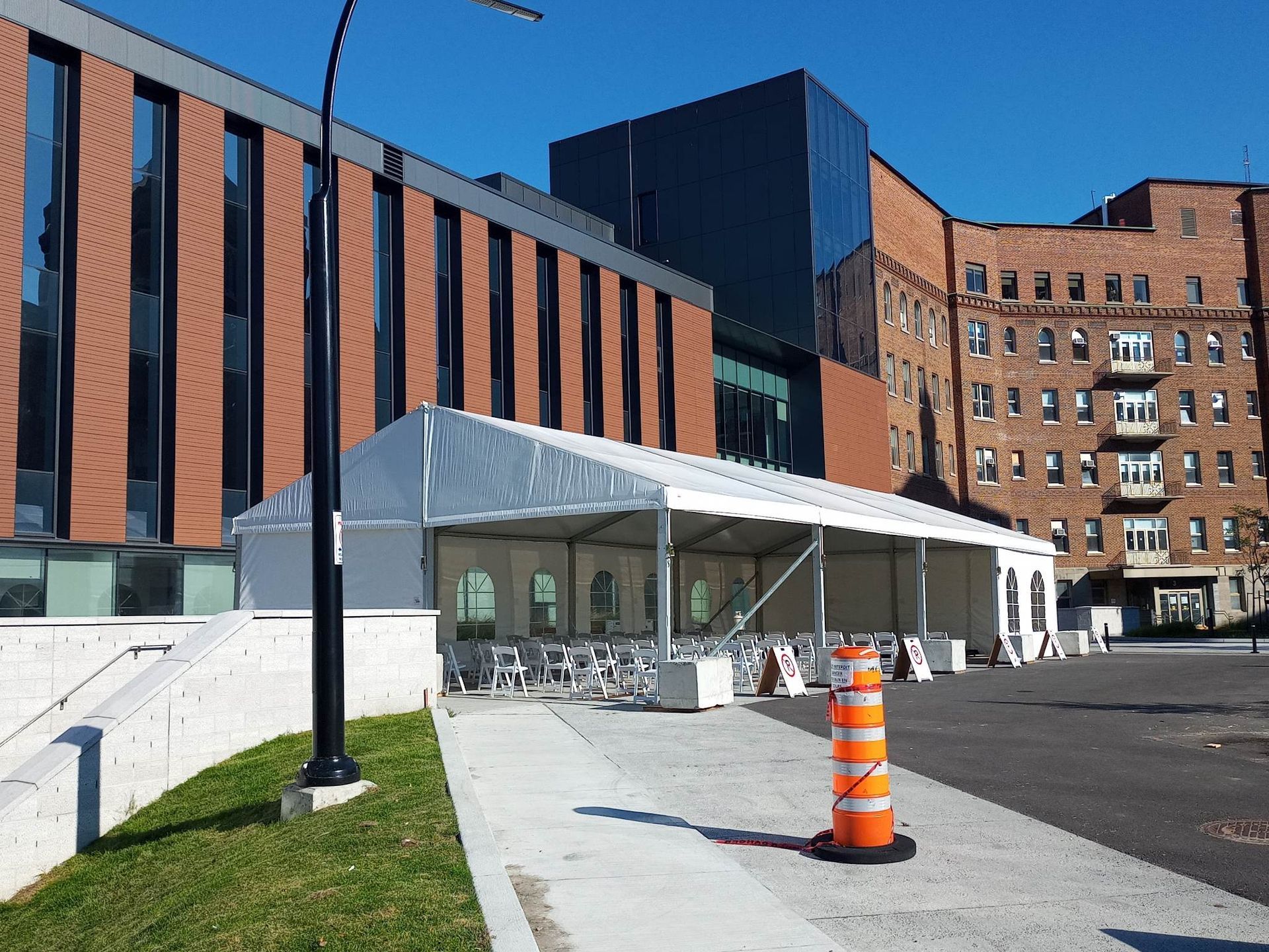 Un grand bâtiment en brique avec une tente blanche devant lui