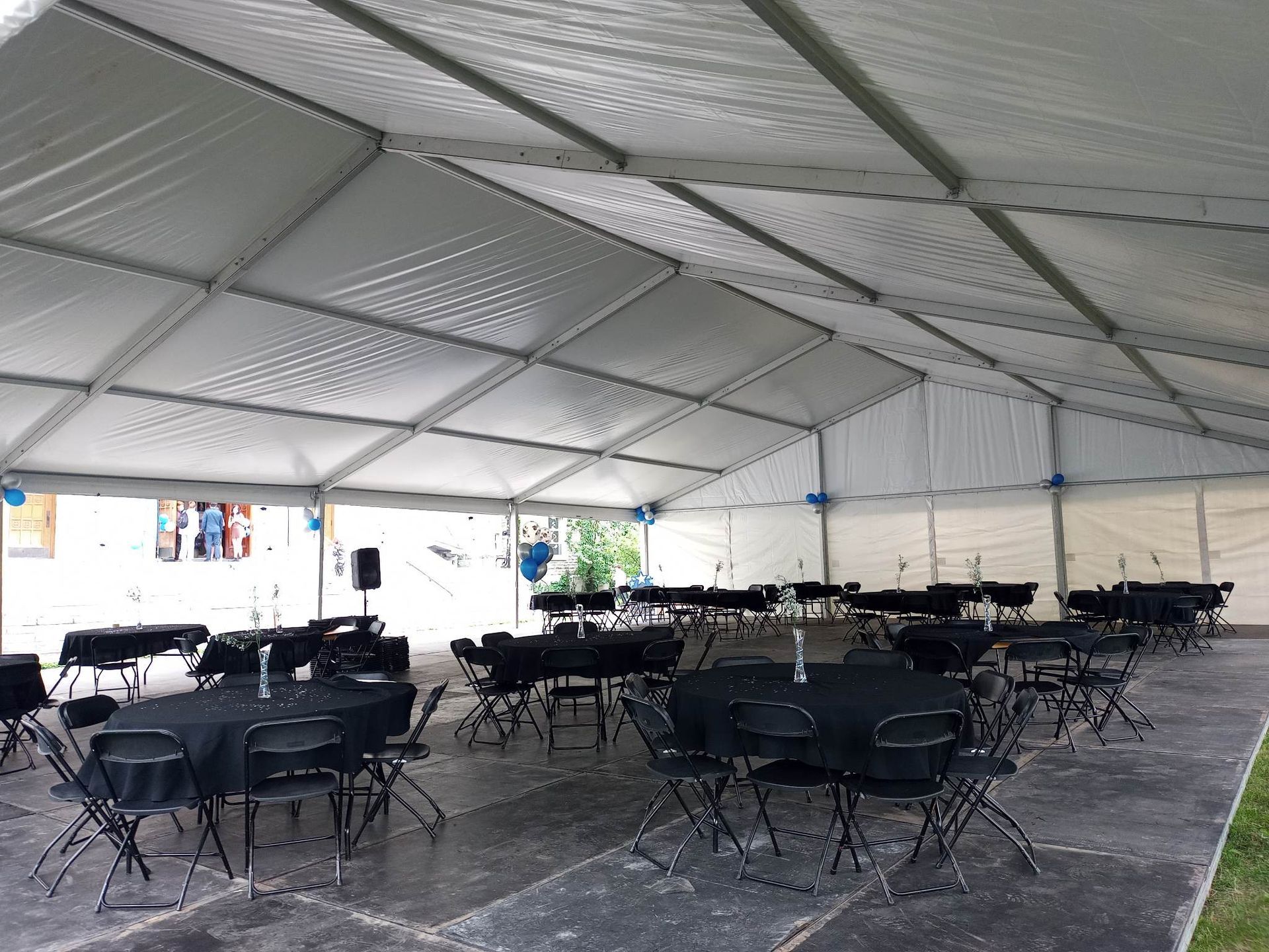 Une grande tente avec des tables et des chaises à l intérieur.