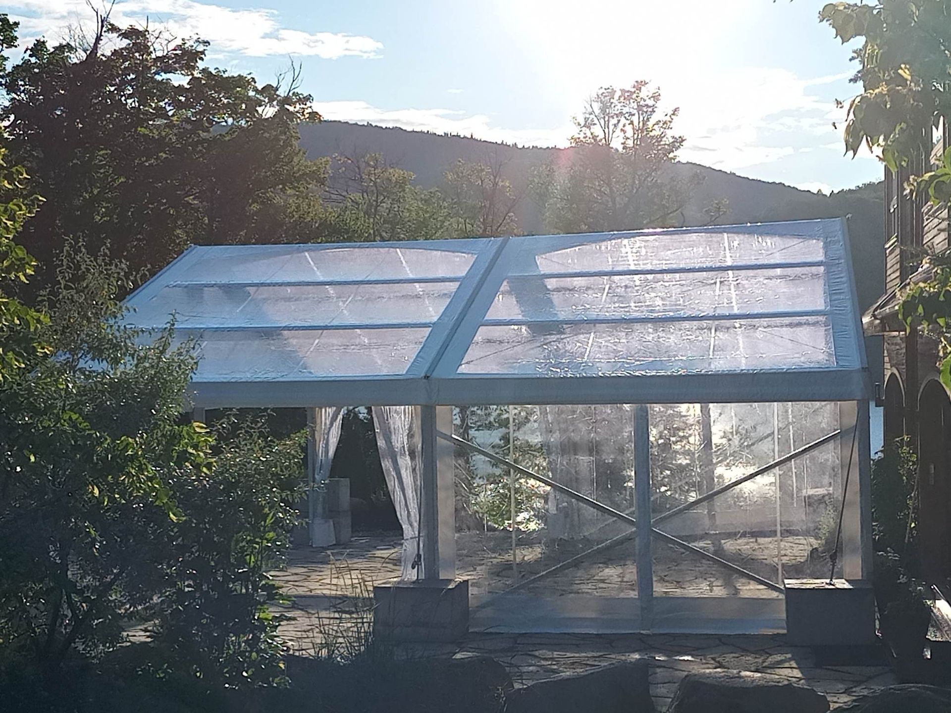 Une tente claire est entourée d arbres et de montagnes