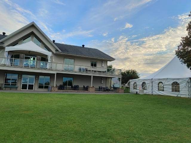 Une grande maison avec une tente devant.