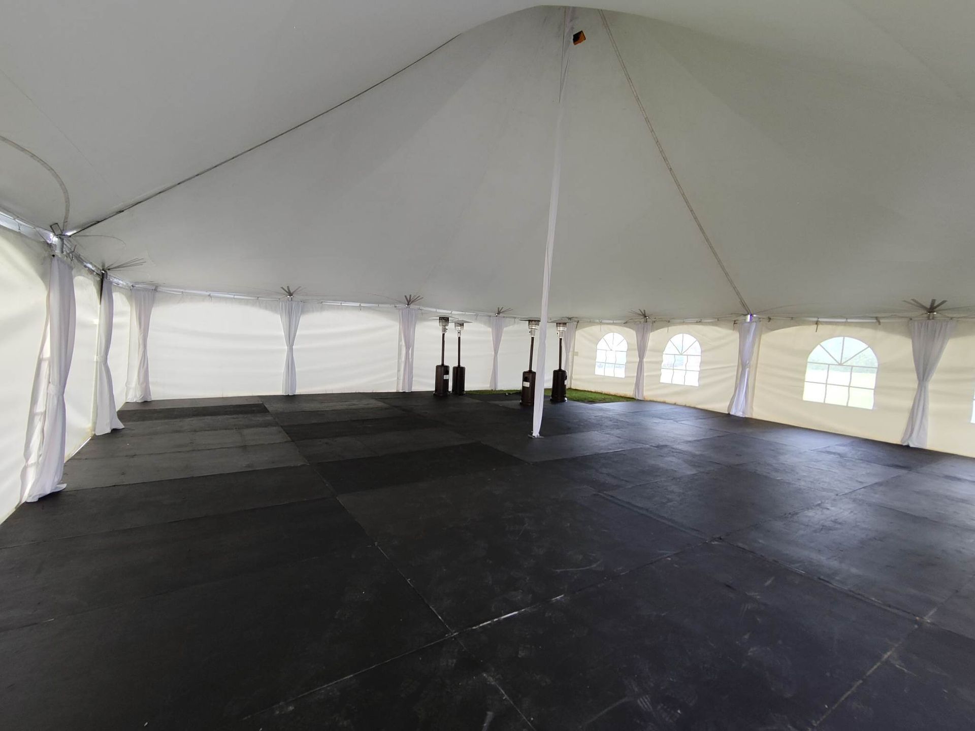 Une tente vide avec un sol noir et des murs blancs.