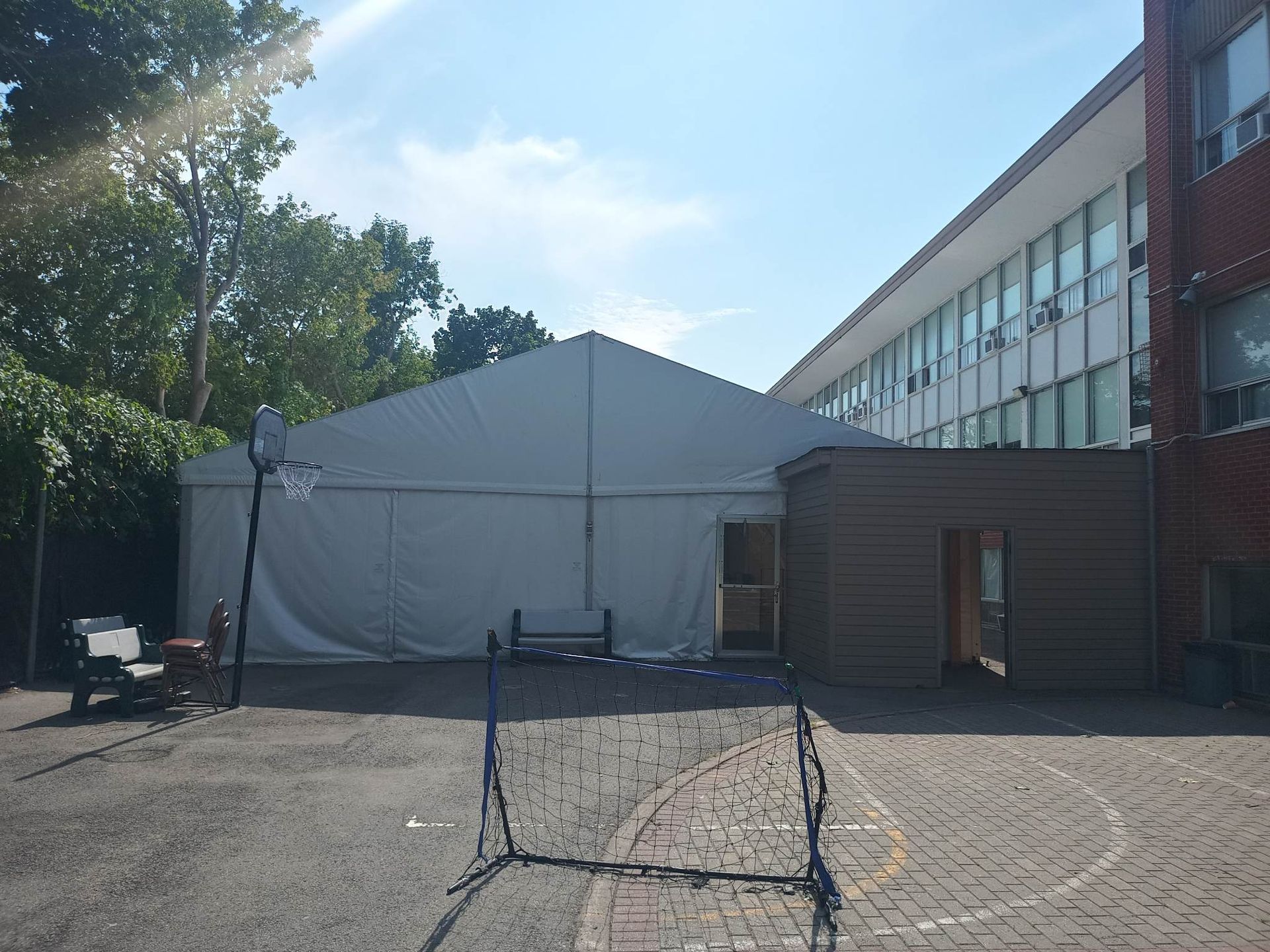 Une grande tente blanche se trouve devant un grand bâtiment