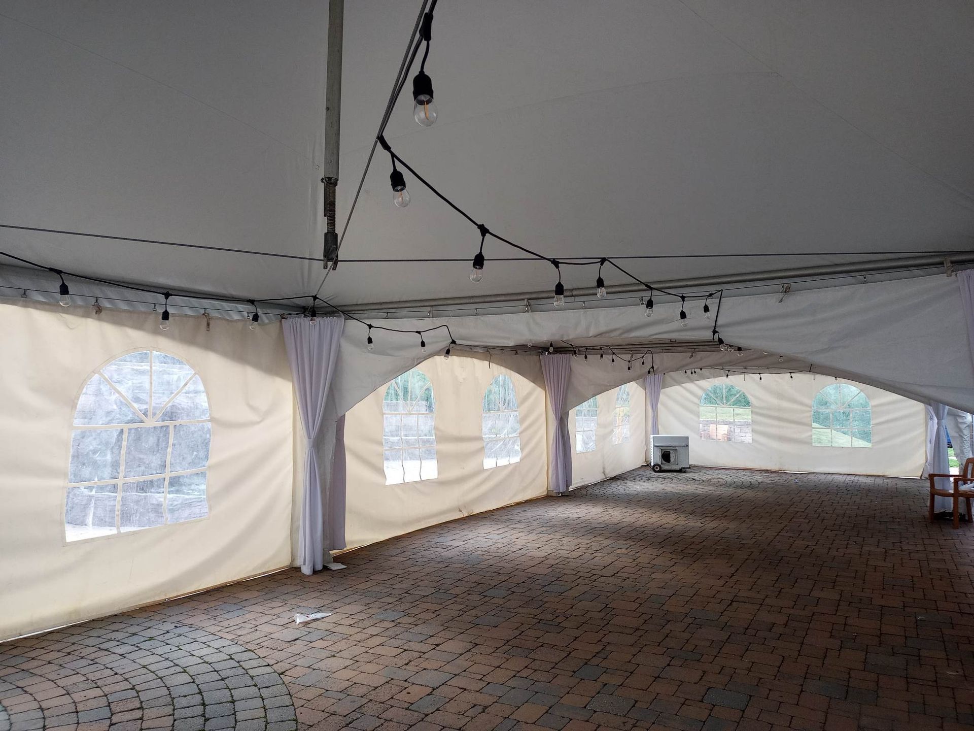 Une grande tente vide avec des fenêtres cintrées et un sol en brique