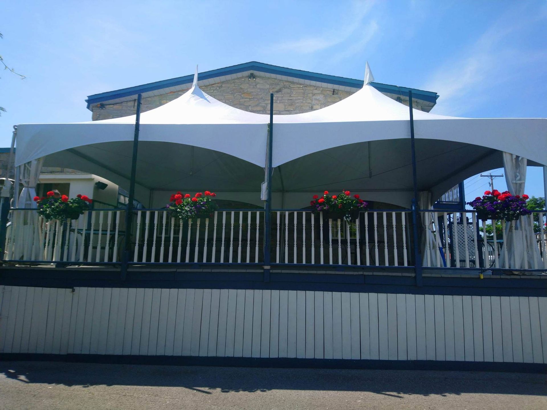 Une tente blanche est posée au sommet d’une clôture blanche