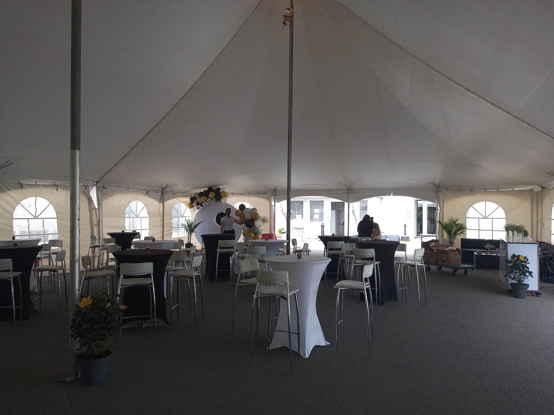 Une grande tente avec des tables et des chaises en dessous