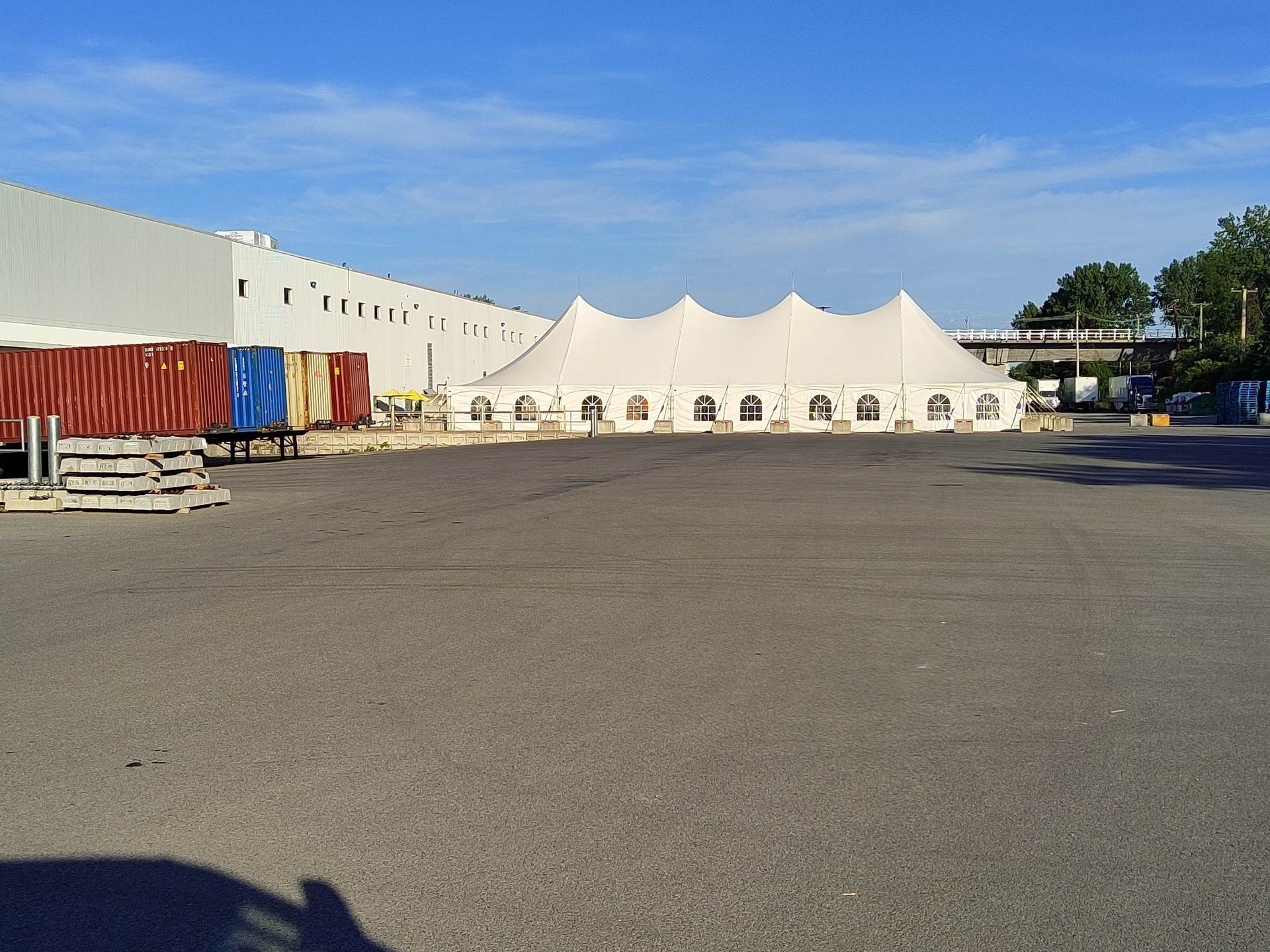 Une rangée de tentes dans un parking devant un immeuble
