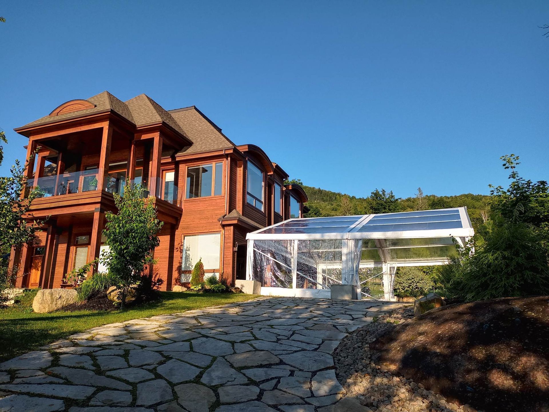 Une grande maison avec une tente claire devant.