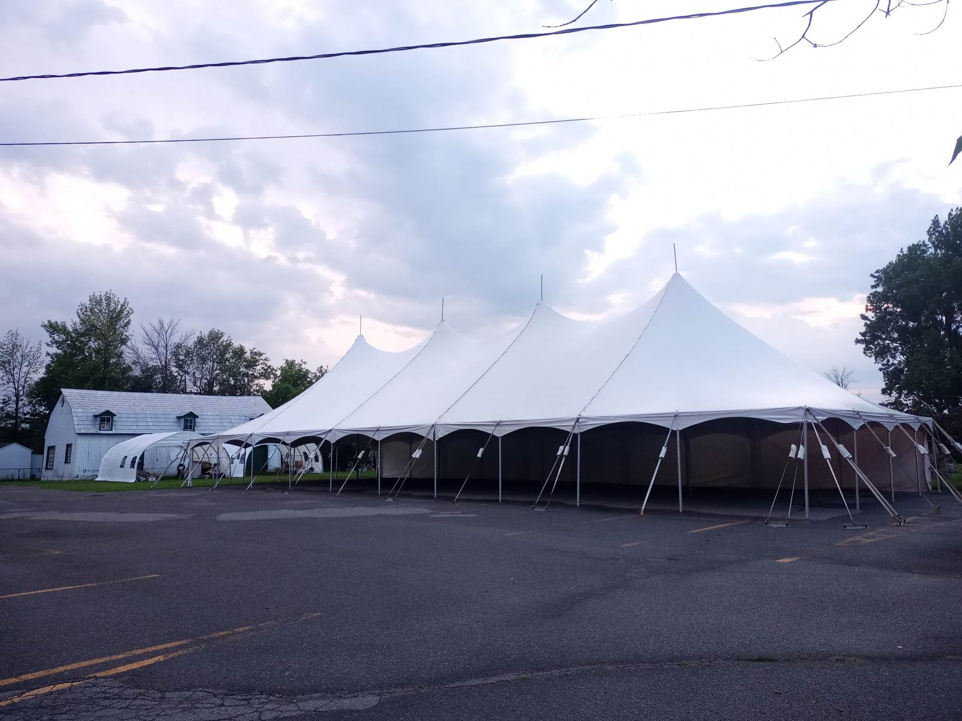 Une grande tente blanche se trouve dans un parking