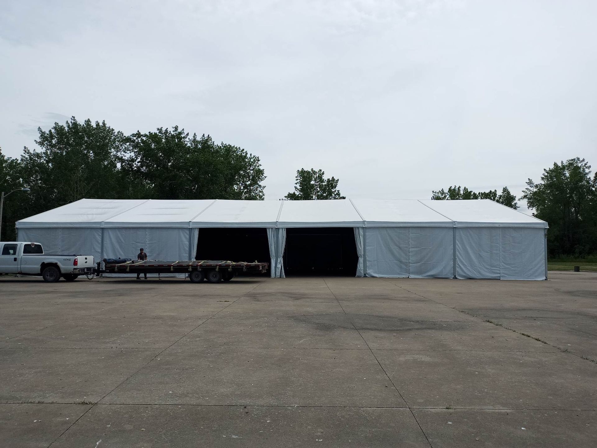 Un camion blanc est garé devant une grande tente blanche