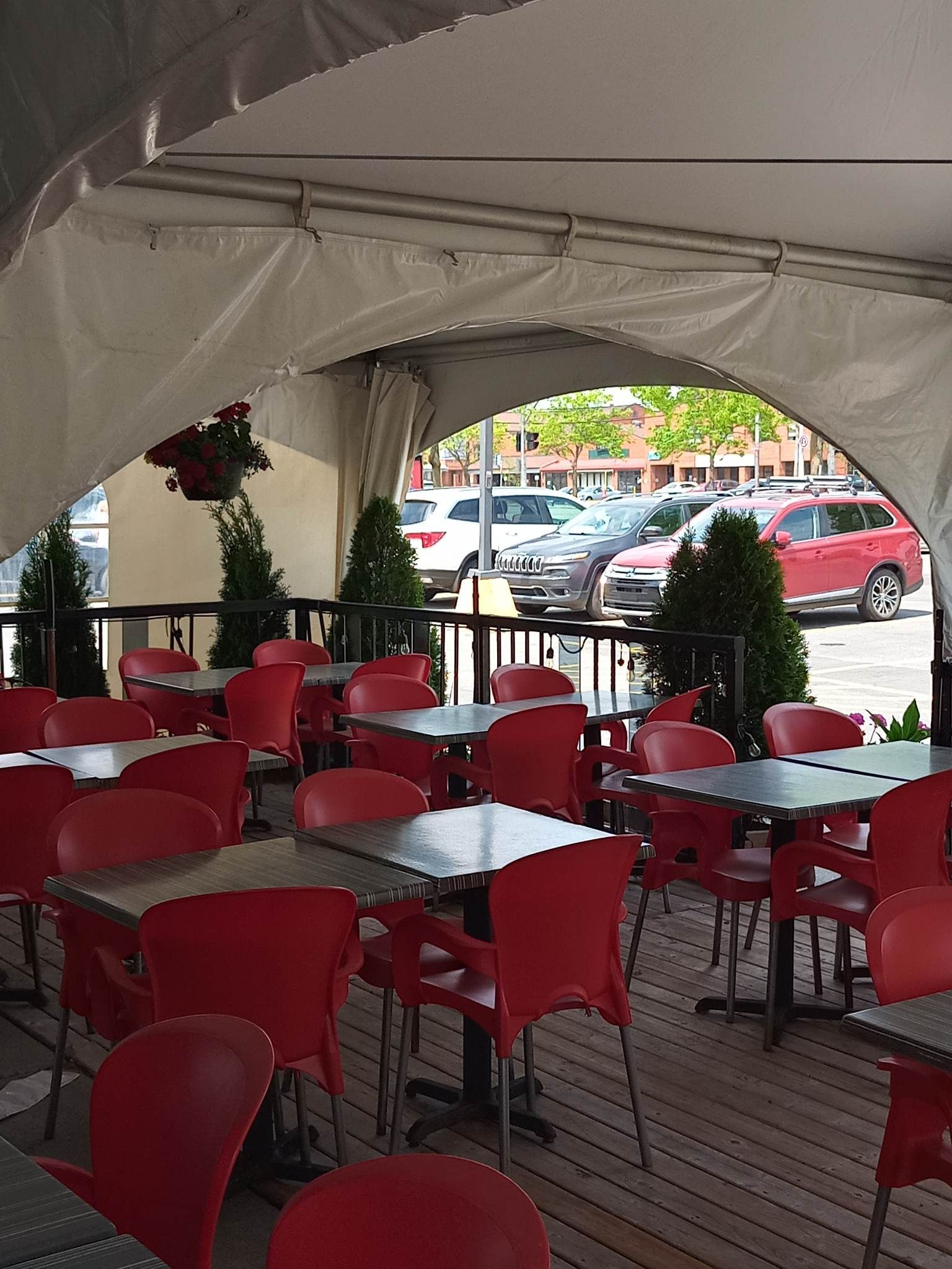 Un restaurant avec des chaises et des tables rouges sous une tente