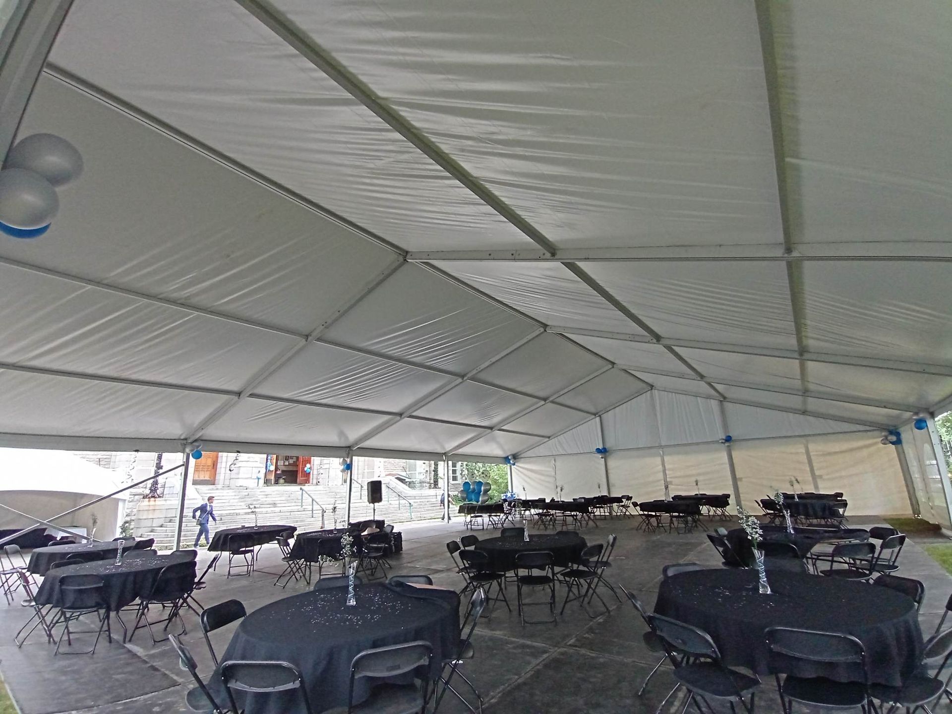 Une grande tente blanche avec des tables et des chaises à l intérieur