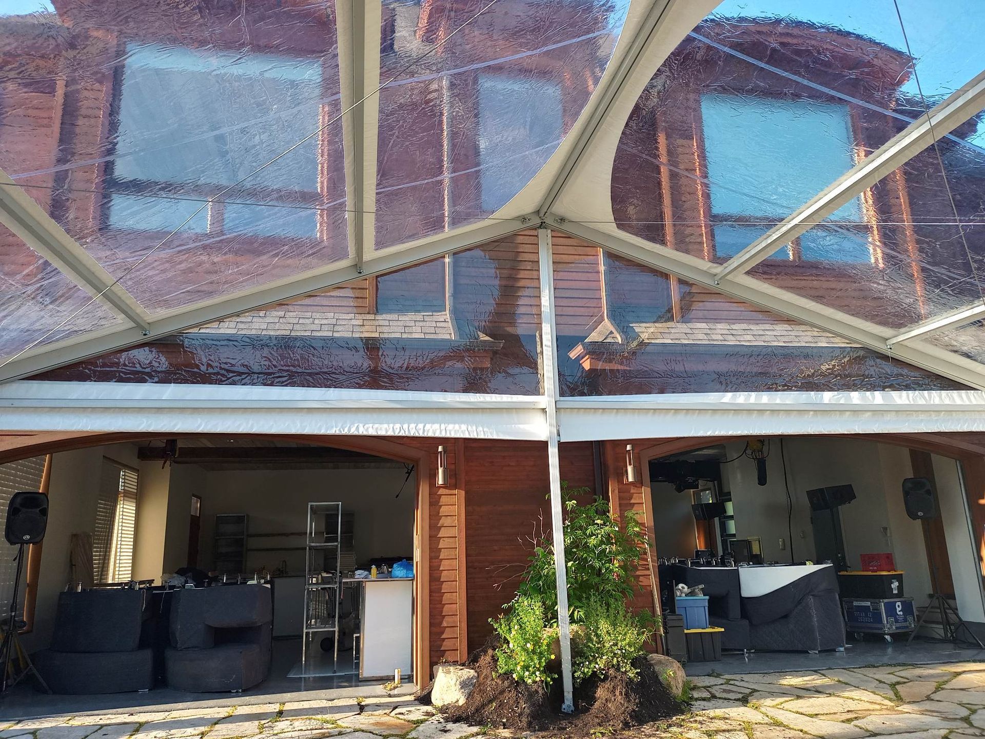 Une tente transparente est dressée devant un bâtiment en brique.