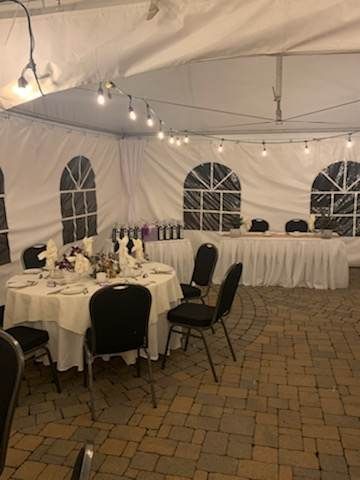 Une tente avec tables et chaises installées pour une réception de mariage.