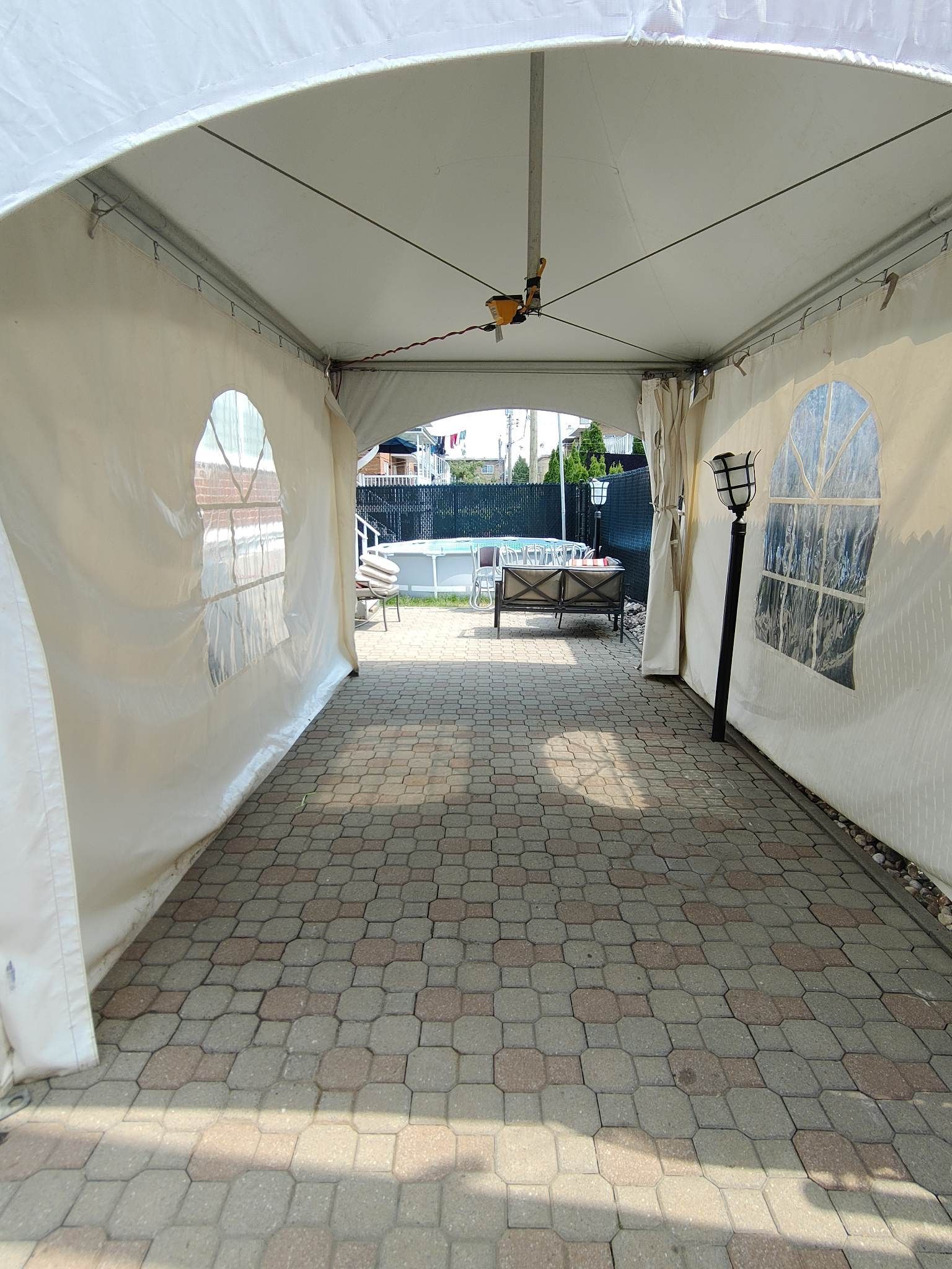 Une tente blanche est posée au sommet d’une passerelle en brique.