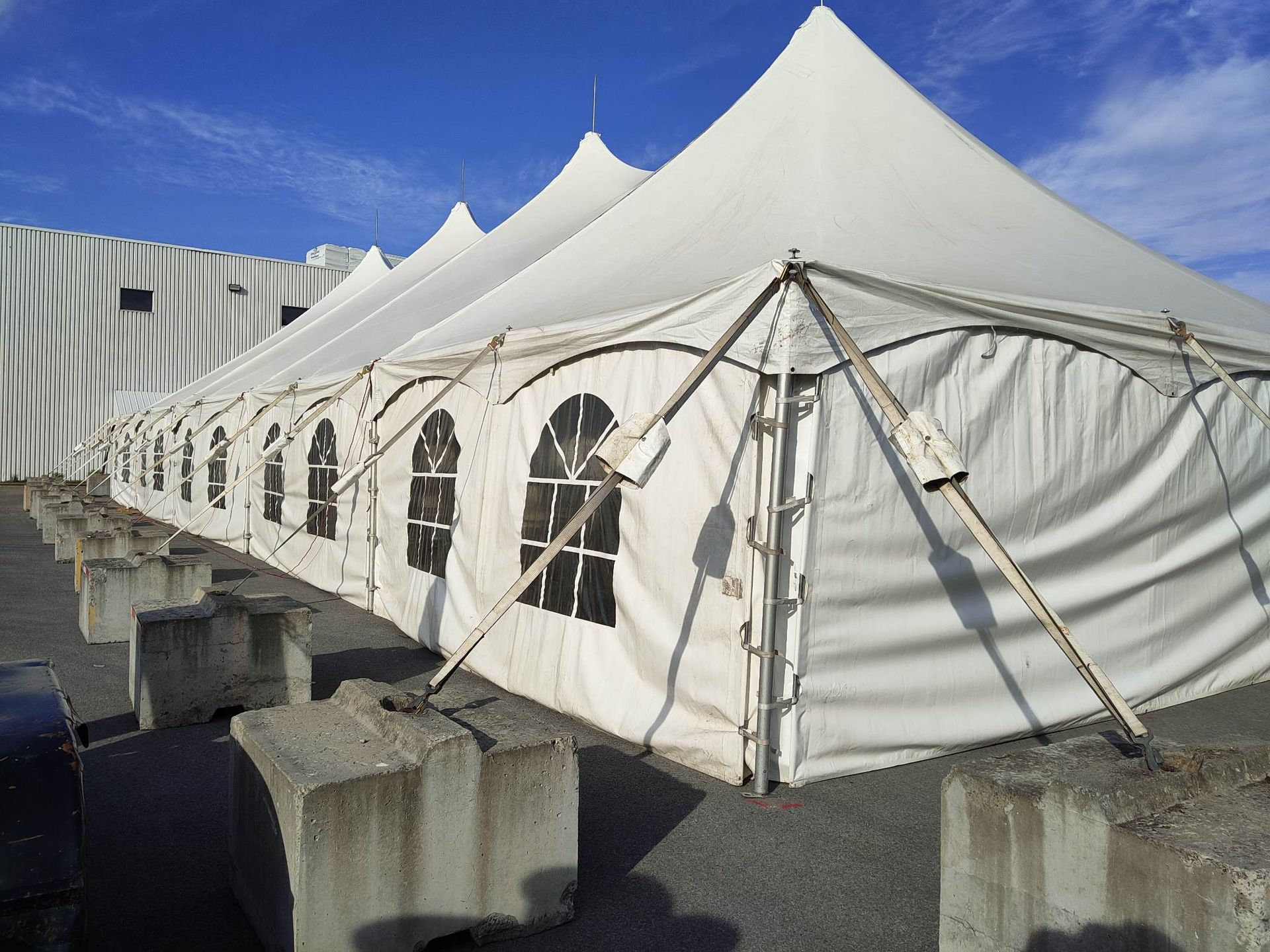 Une rangée de tentes blanches posées sur des blocs de béton