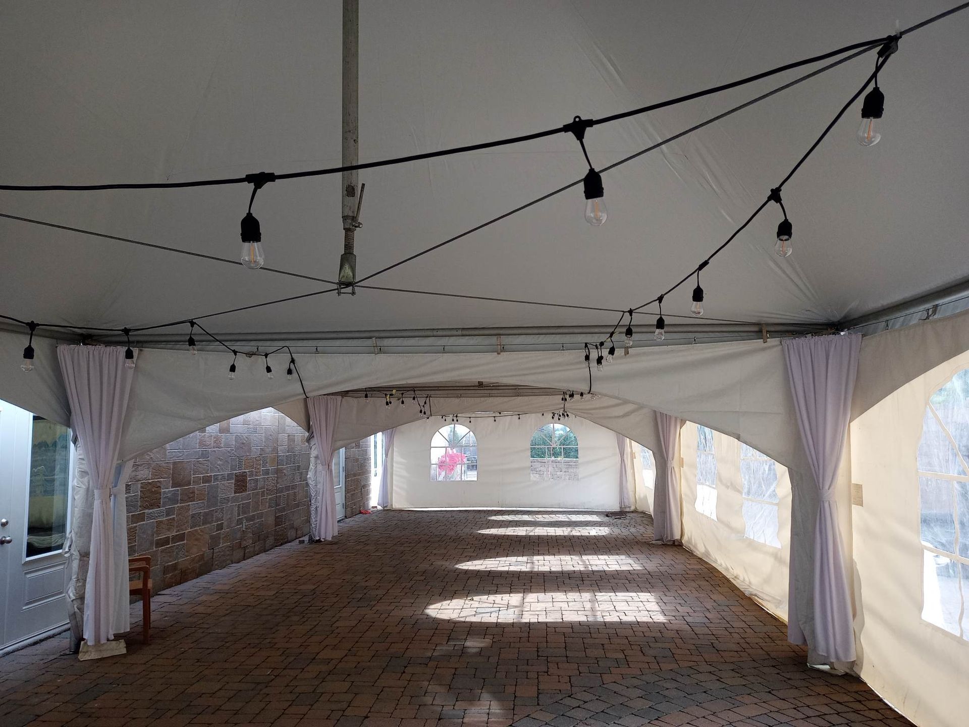 Une grande tente vide avec des lumières suspendues au plafond