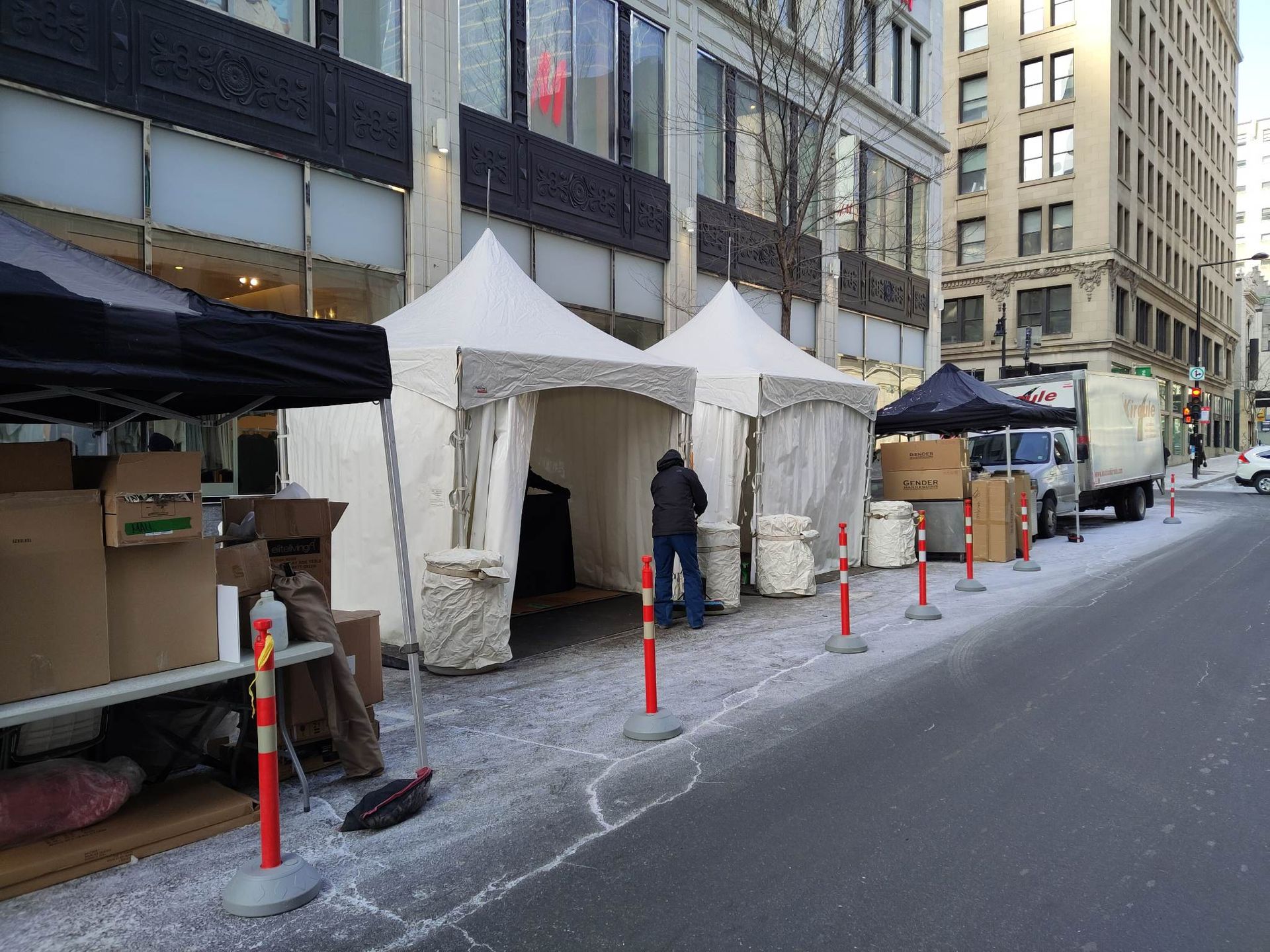 Un homme se tient devant une tente au bord de la route.