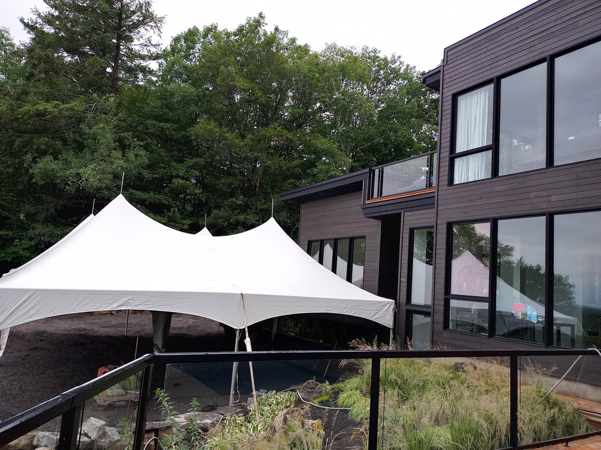 Une tente blanche est dressée devant un grand bâtiment.