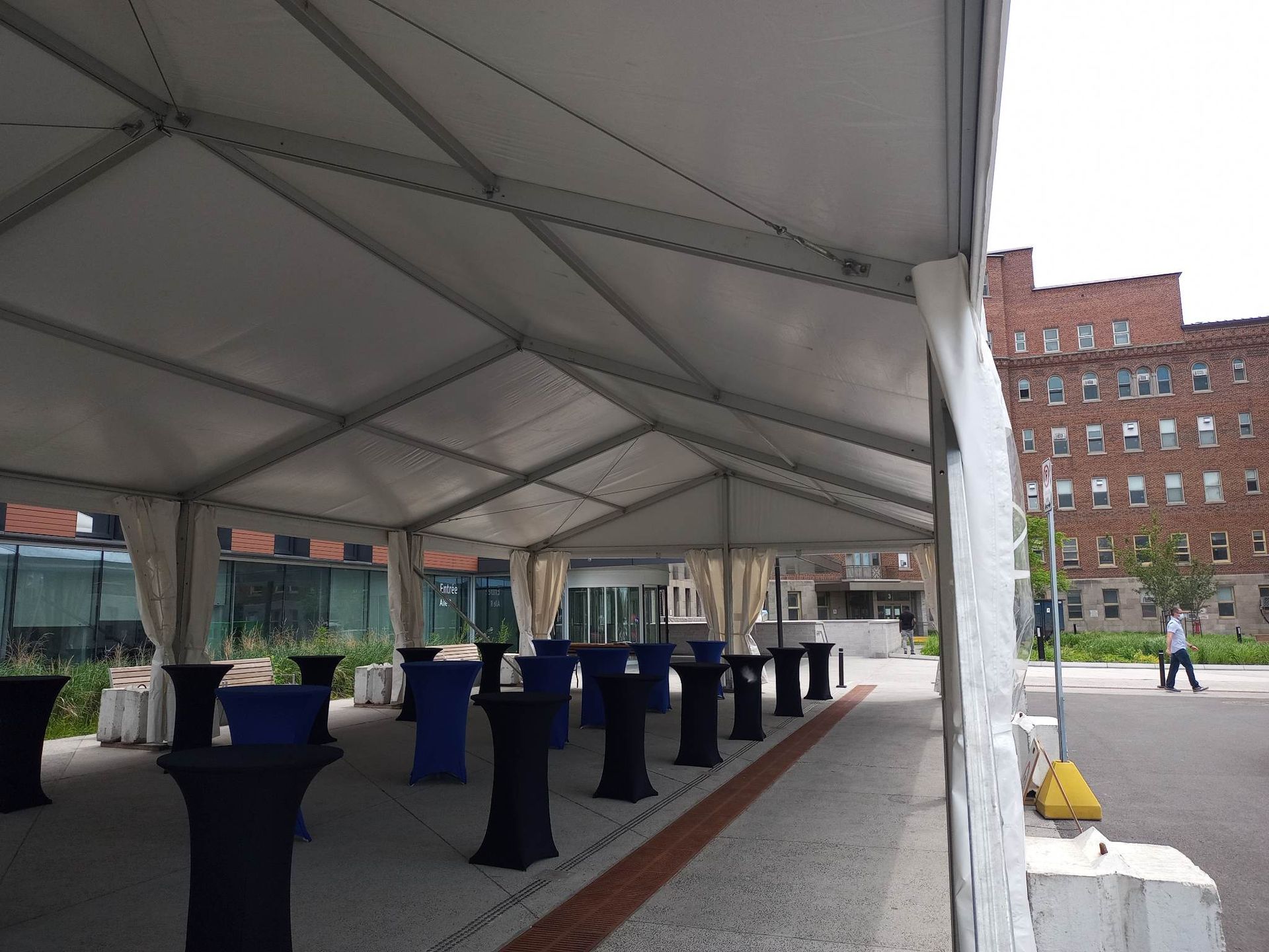 Une tente blanche avec des tables bleues en dessous
