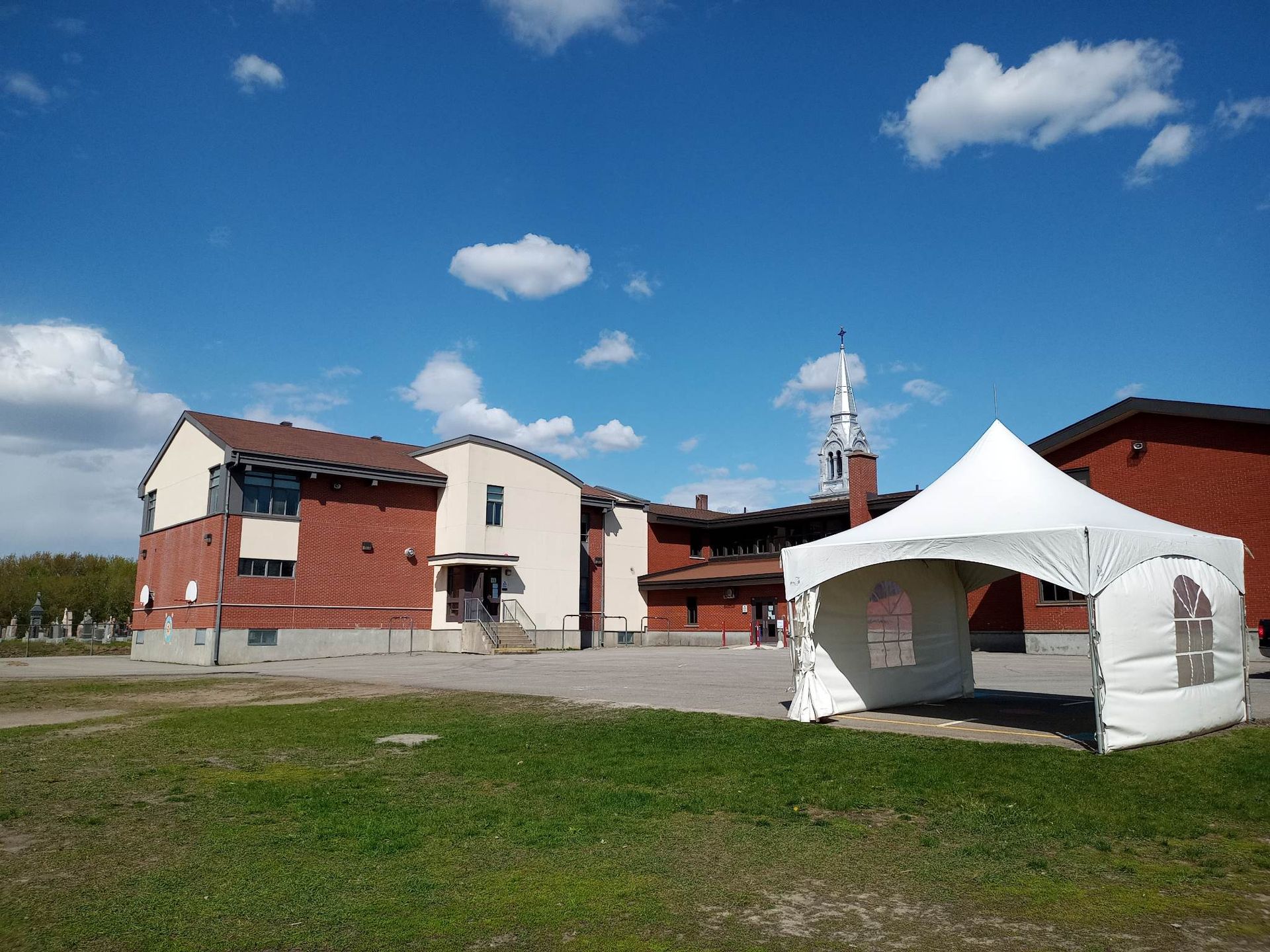 Un grand bâtiment en brique avec une tente blanche devant lui