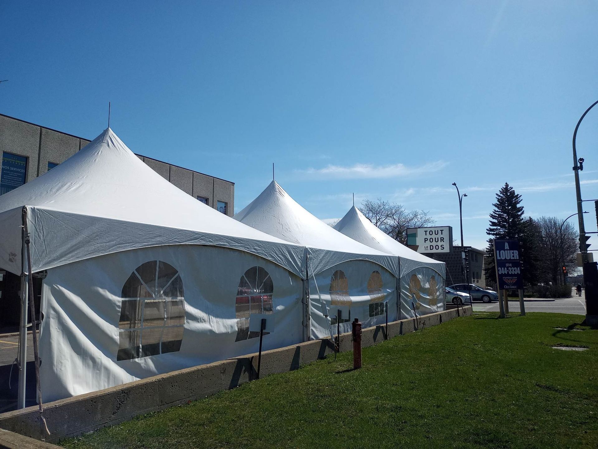Une rangée de tentes blanches sont alignées sur le bord de la route
