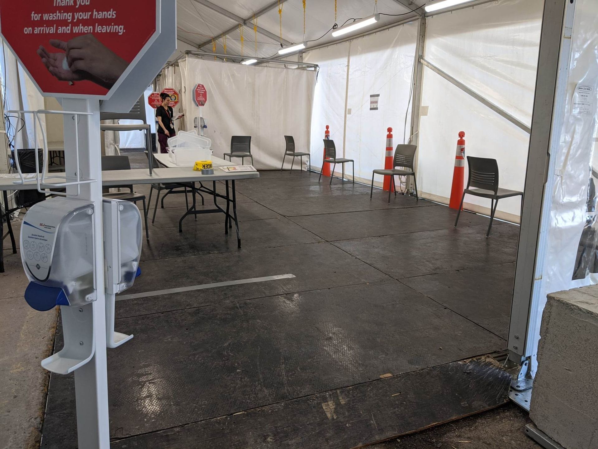 Une grande tente avec des tables et des chaises à l intérieur.