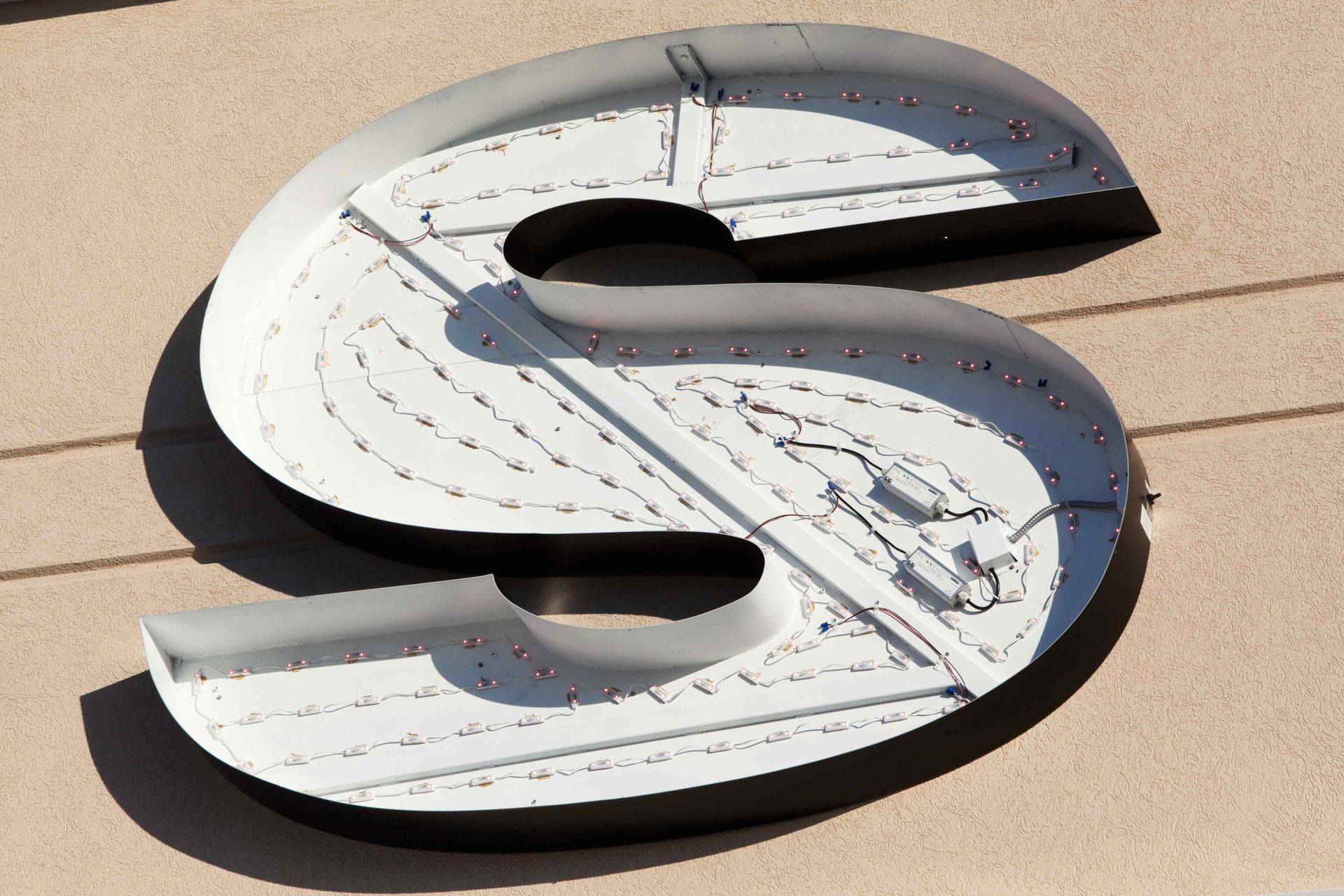 A white letter s is laying on the ground.