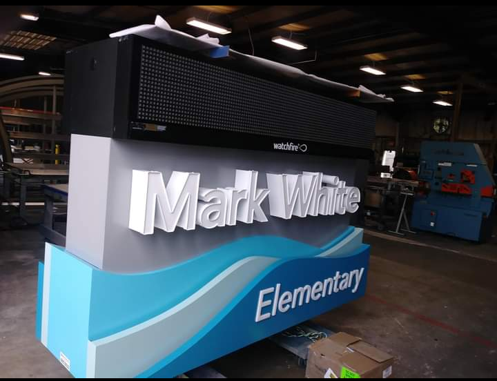 A large blue and white sign is sitting in a warehouse. A large blue and white sign is sitting in a warehouse.