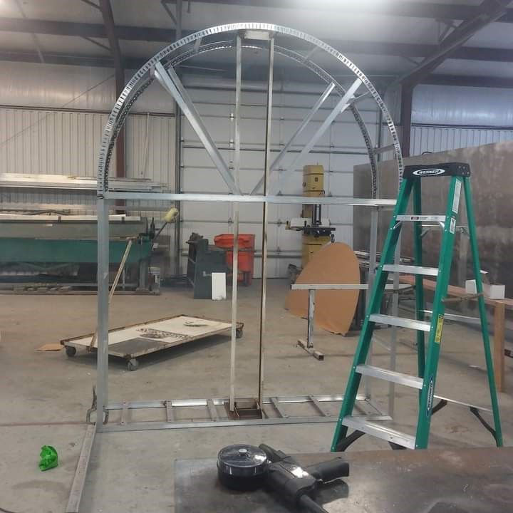 A green ladder is sitting in front of a metal structure.