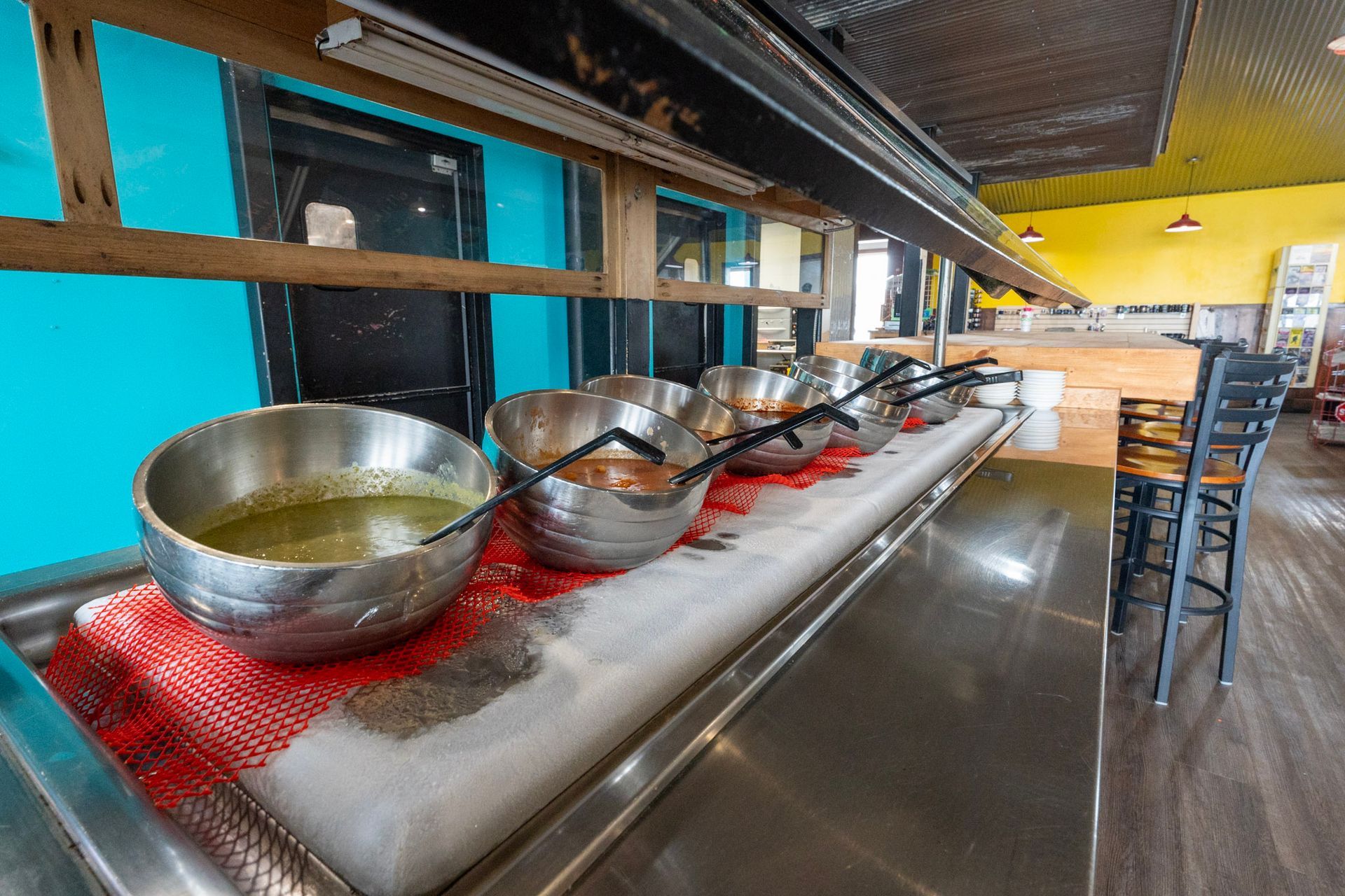 A buffet line with bowls of food on it in a restaurant.