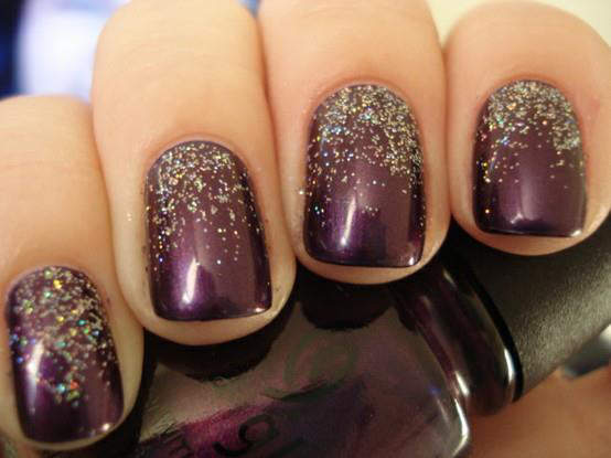Hand with dark plum glitter nail polish and a sparkly silver gradient