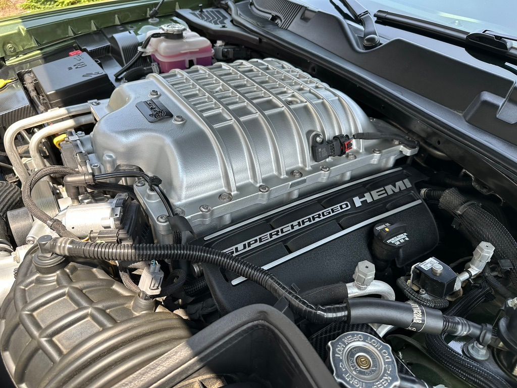 Close-up view of a Dodge Challenger engine, silver supercharger with black 