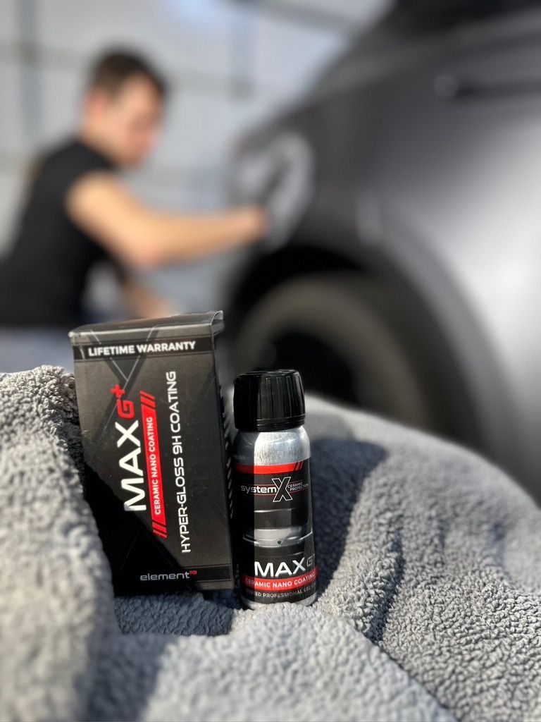 A person applies ceramic coating to a car. The product box and bottle sit in front.