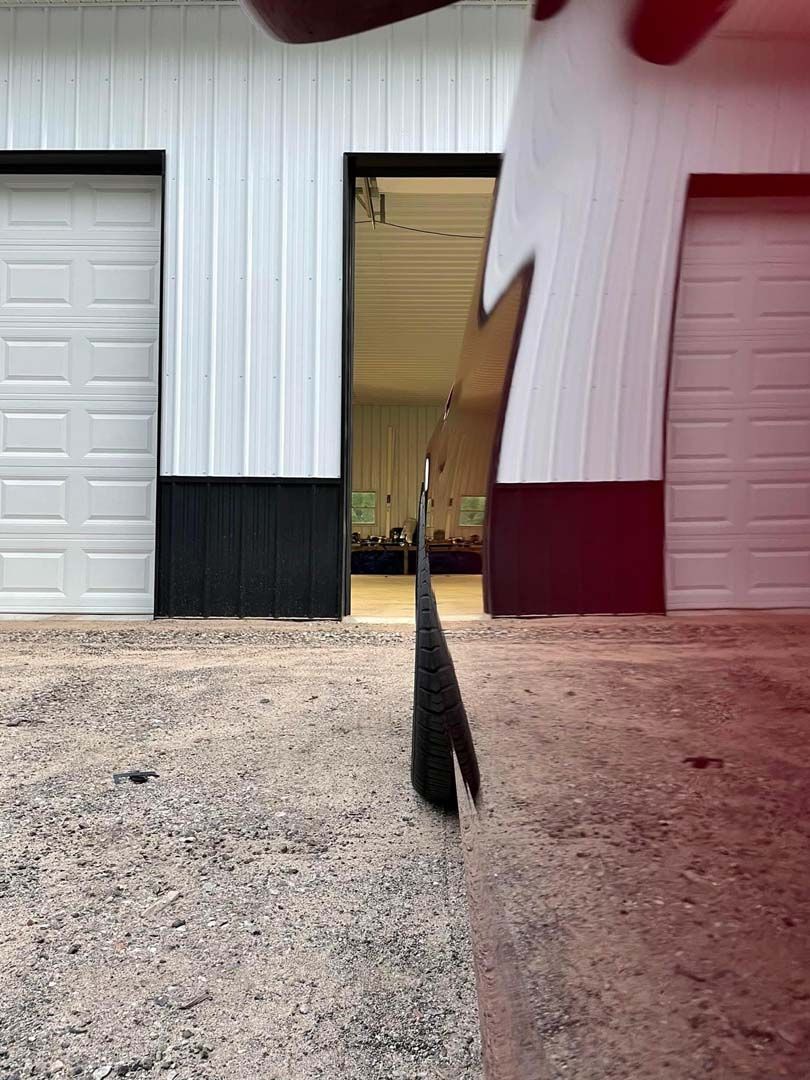 A distorted view of a building with doors, focusing on a dark object in the center.