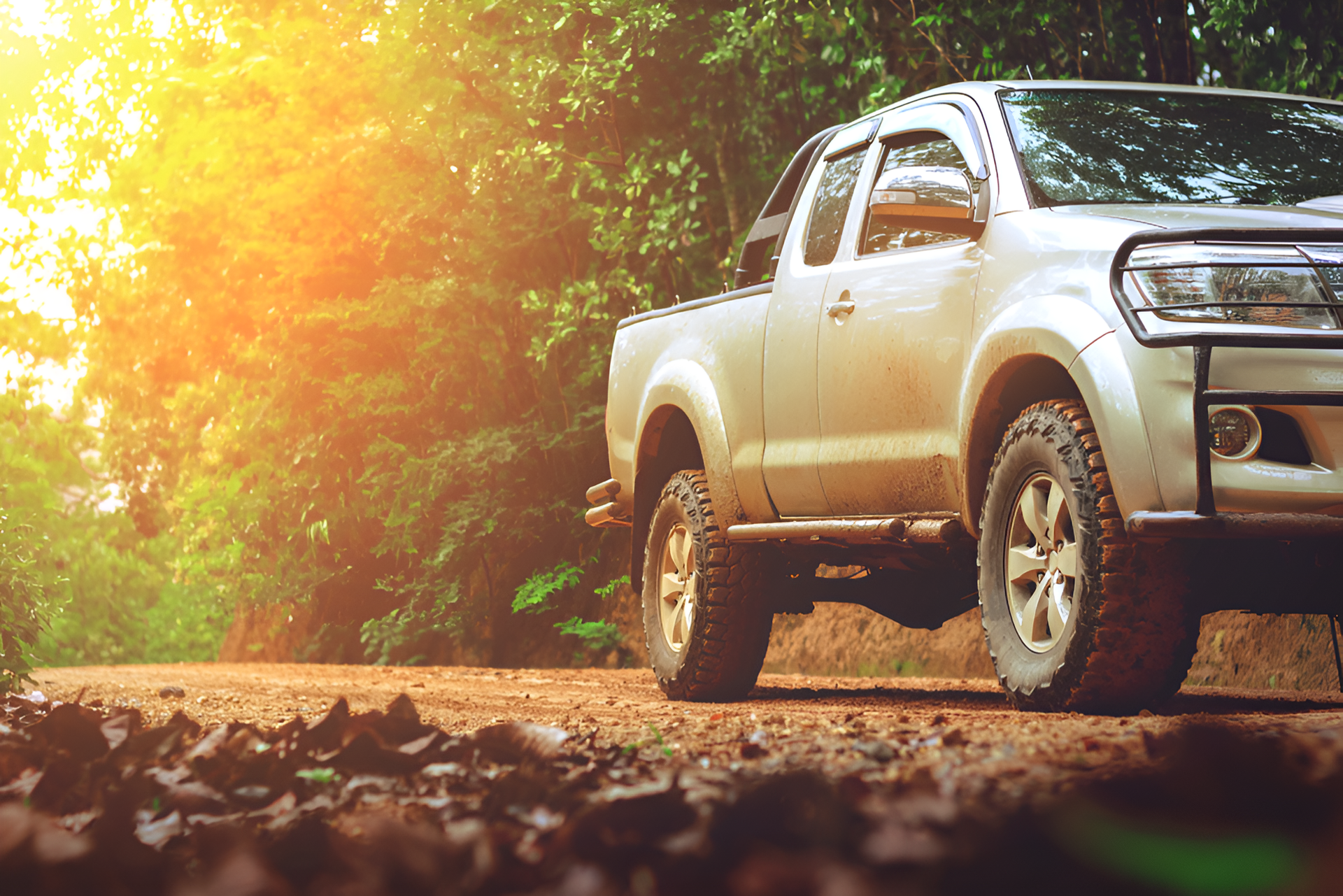 A White Truck Is Parked On A Dirt Road In The Wood — Borg's Brake & Front End Service In Mackay, QLD