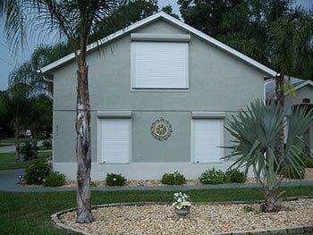 Hurricane Shutters Ormond Beach FL — Residential House with White Hurricane Shutter on windows in Ormond Beach, FL