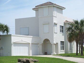 White house with storm shutter — hurricane shutters Ormond Beach FL in Ormond Beach, FL